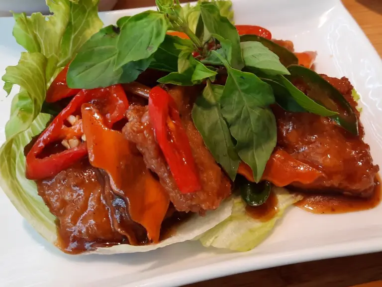 Sweet and sour vegan steak with basil and red chilli on lettuce