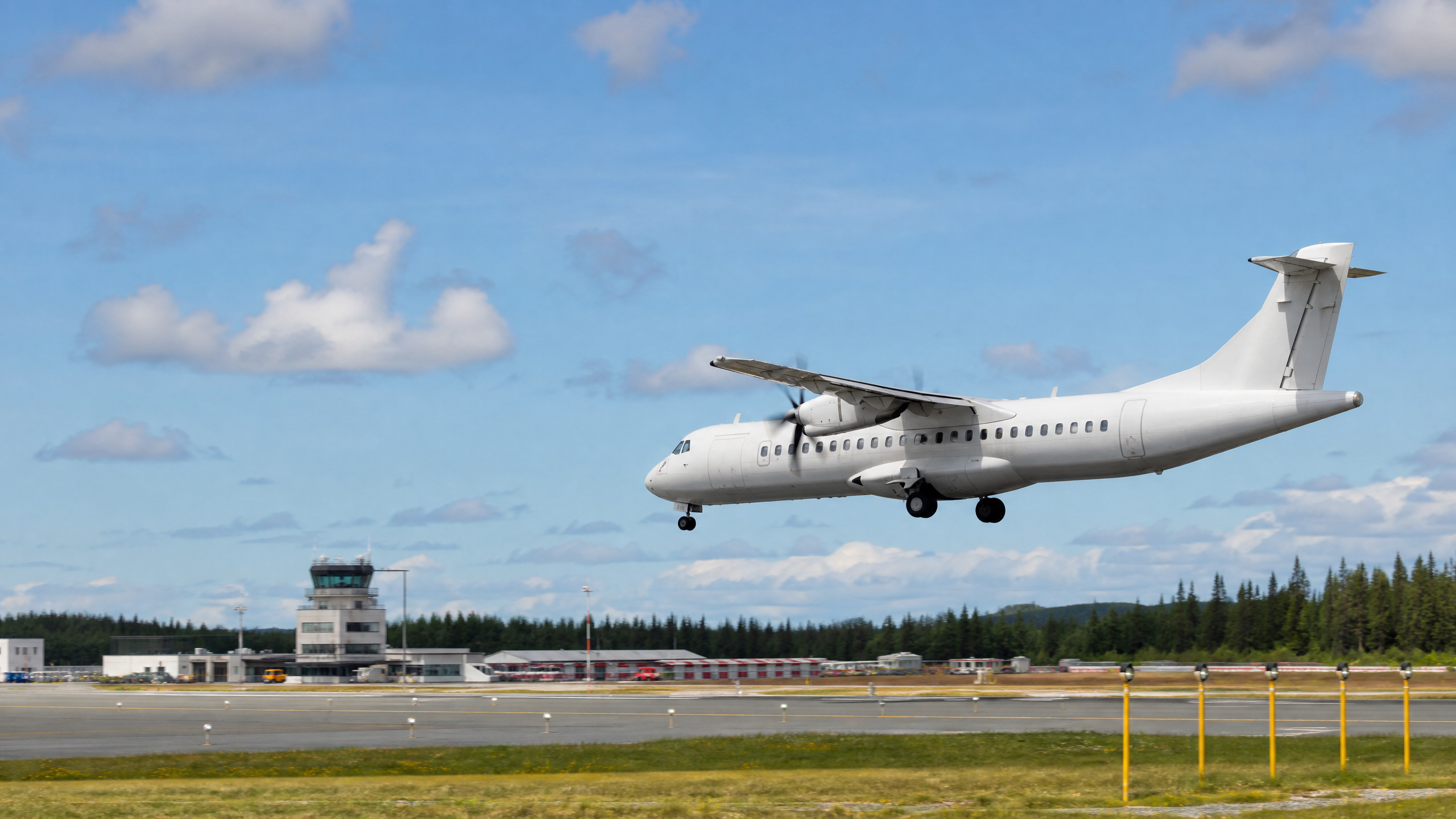 Side view of a regional airplane approaching a runway for landing