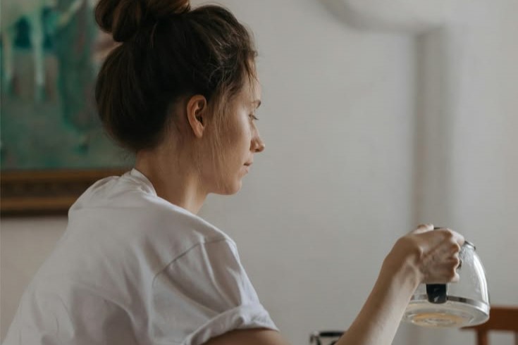 "Woman sitting at her kitchen table looking uncertain — the overlap between perimenopause and burnout in high-achieving midlife women" "Woman sitting at her kitchen table looking uncertain — the overlap between perimenopause and burnout in high-achieving midlife women"
