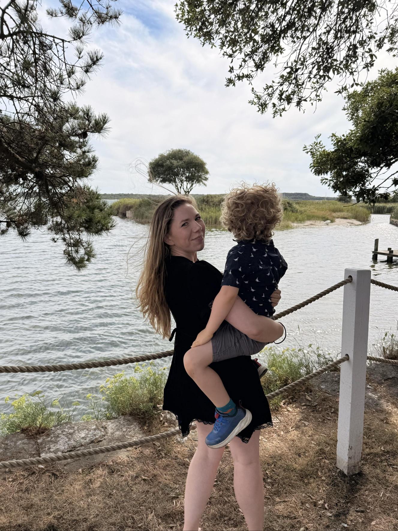 Marie holding her son beside the water in Christchurch, Dorset