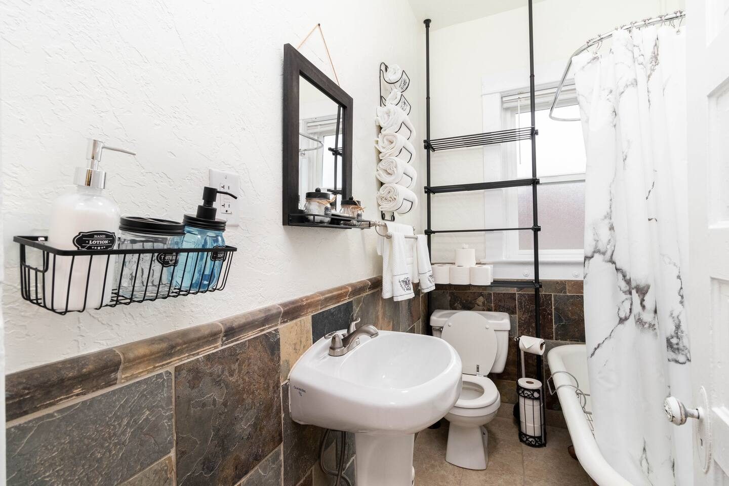 Unit 1 bathroom after, with a clawfoot tub and slate tile wall