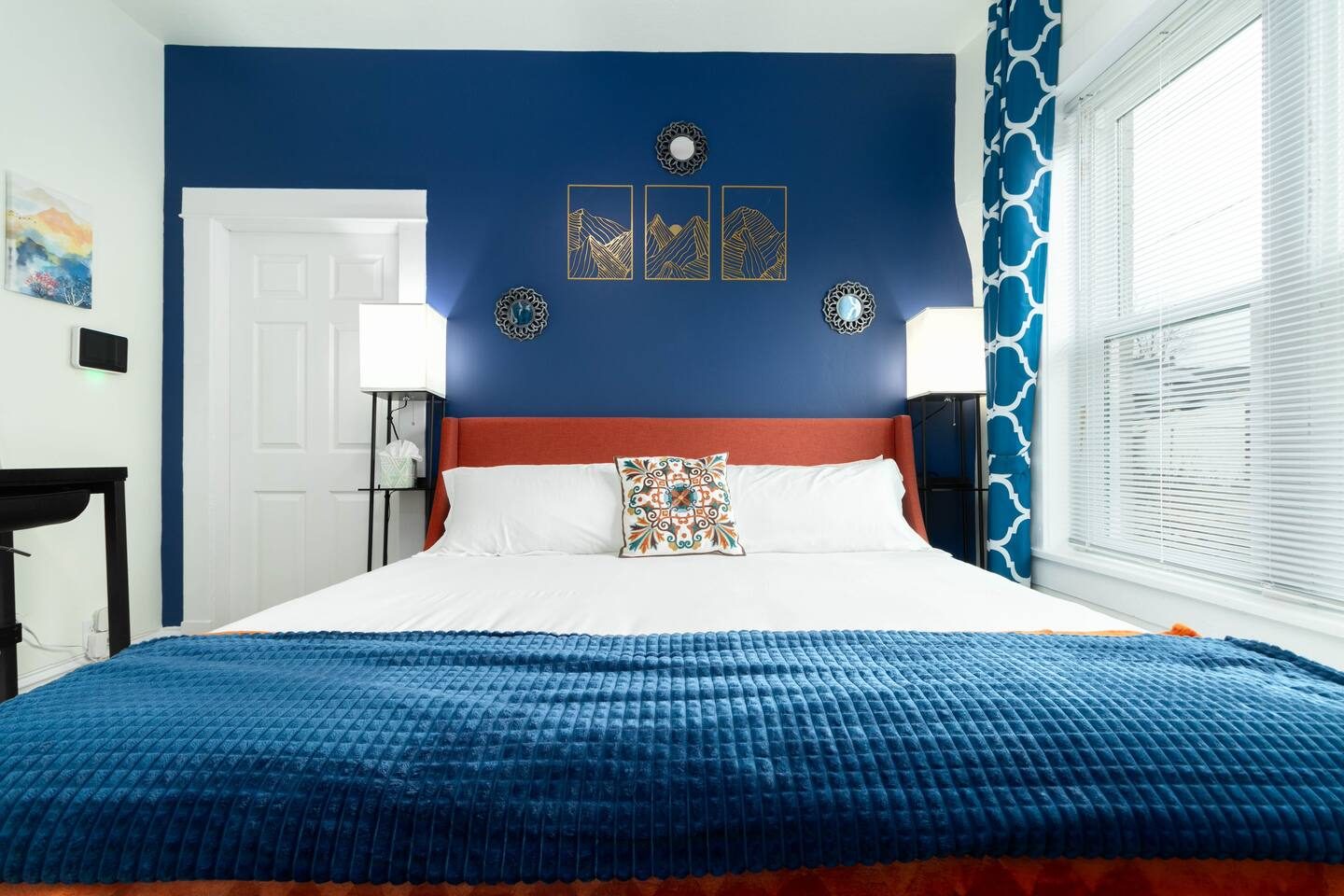 Unit 1 after: the same space, now the bedroom, with a deep blue accent wall