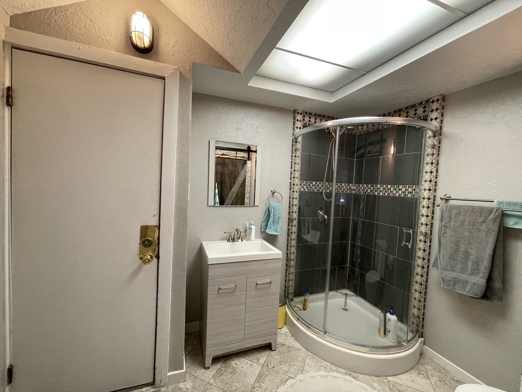 Unit 2 bathroom before, with a corner shower