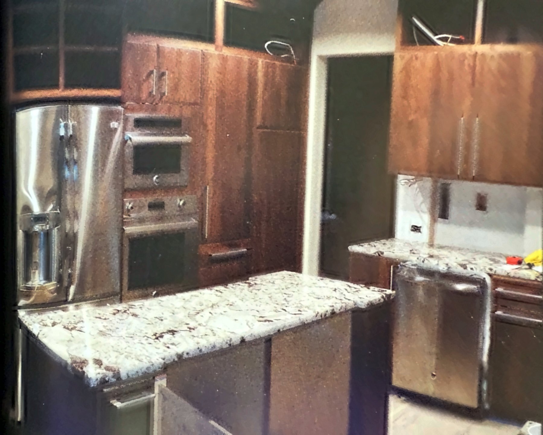 Kitchen remodel late stage with granite counters, wall ovens and refrigerator in place