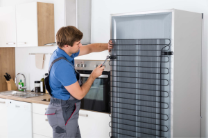 a man working on the back of a refrigerator
