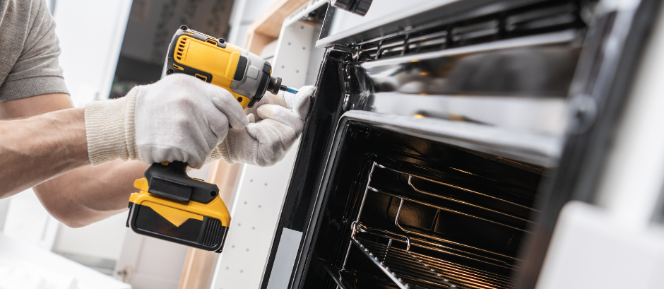 a pic of a person repairing and oven or stove