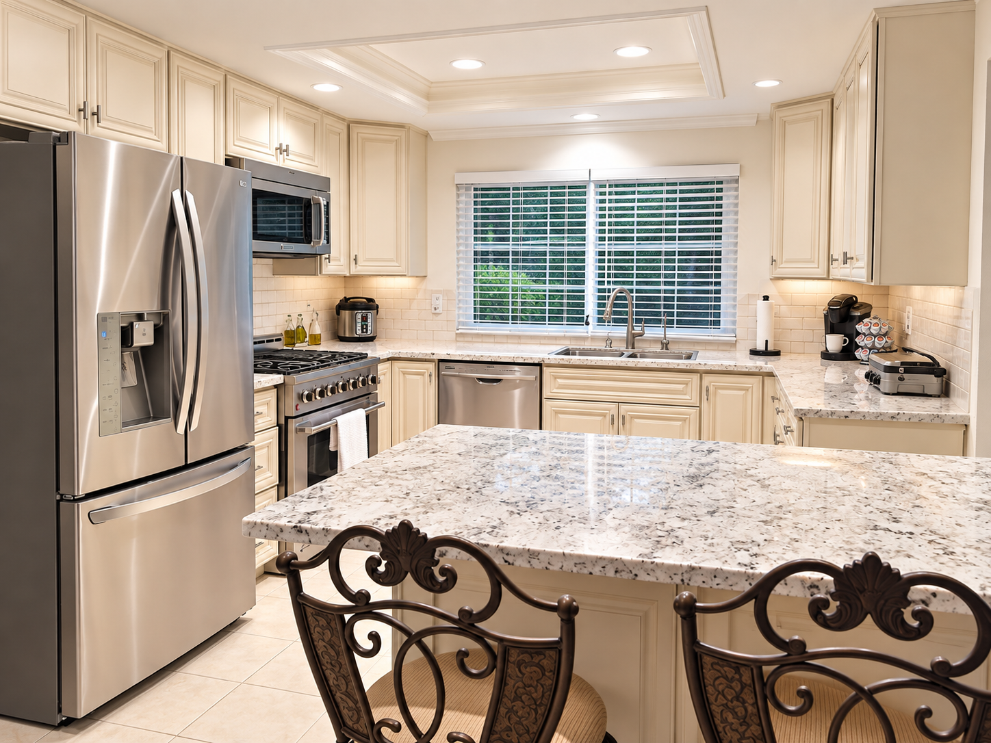 Finished kitchen remodel with white cabinets, granite island and stainless appliances