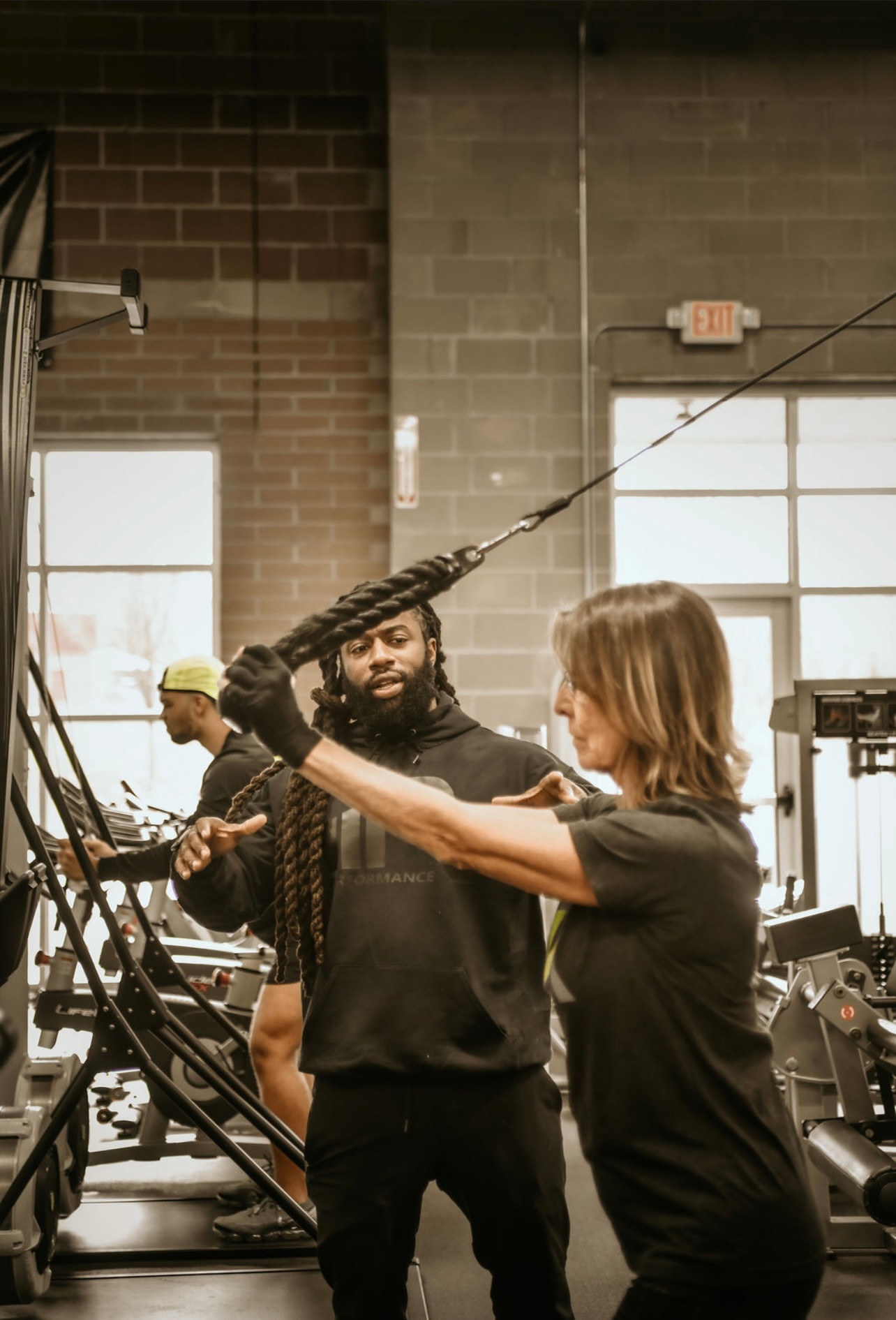 A client practicing a cable exercise with coaching at iRISE