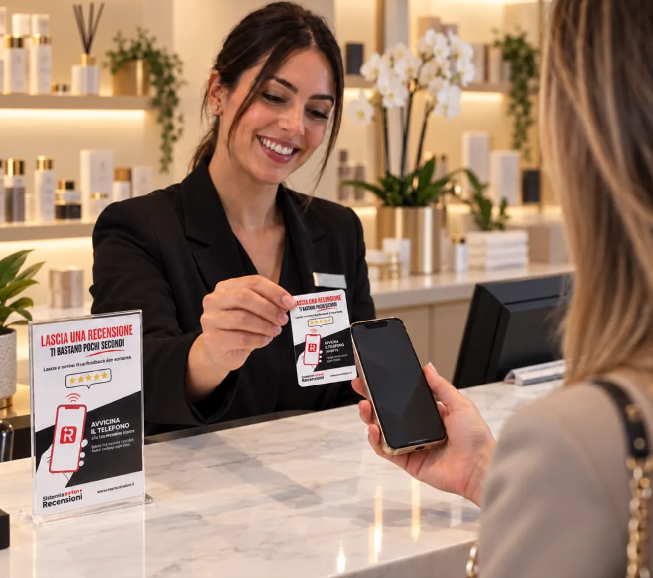 Una persona dello staff porge una card NFC a una cliente alla reception, accanto a un espositore