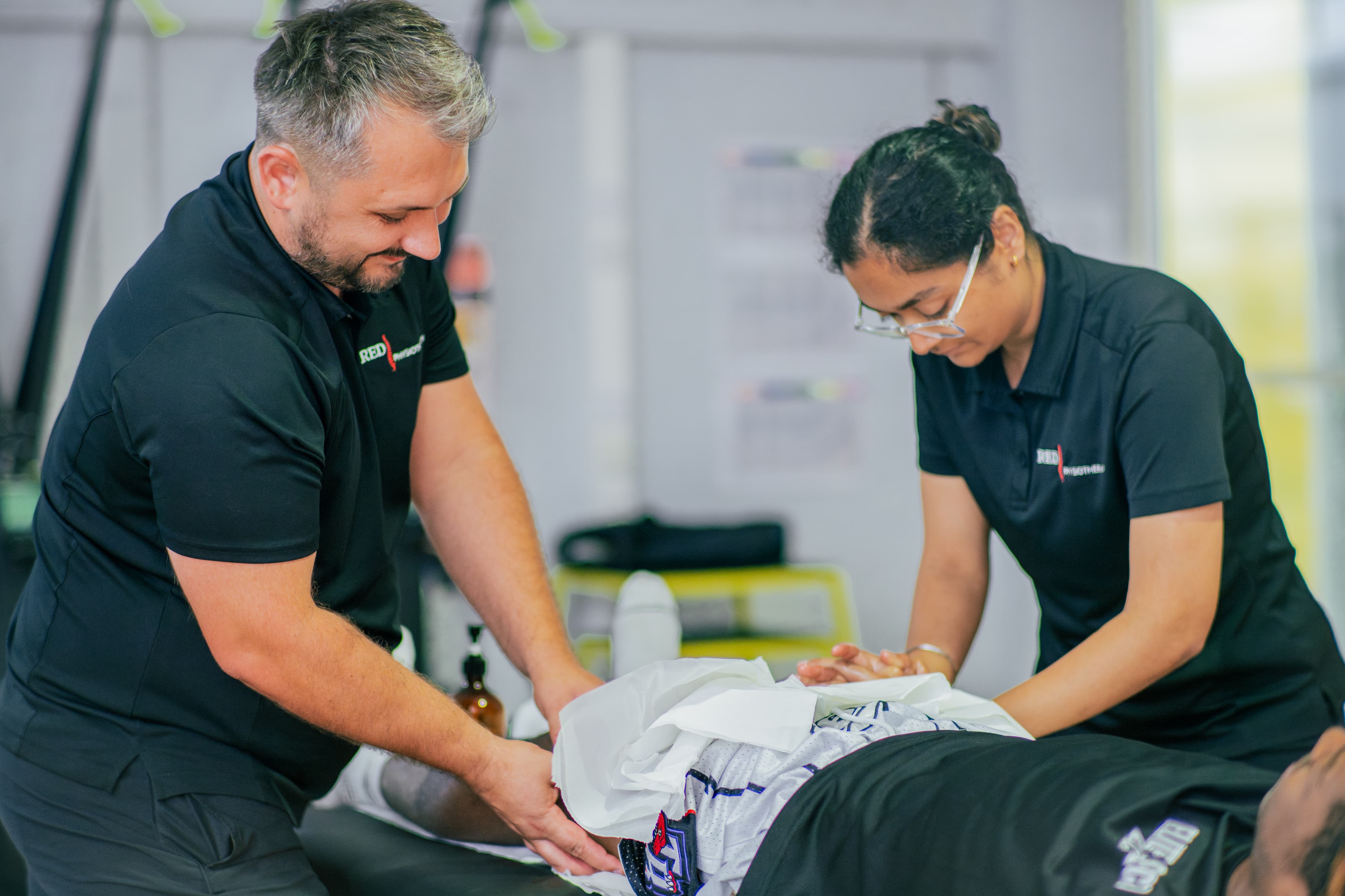 RED Physiotherapy clinicians treating a patient together