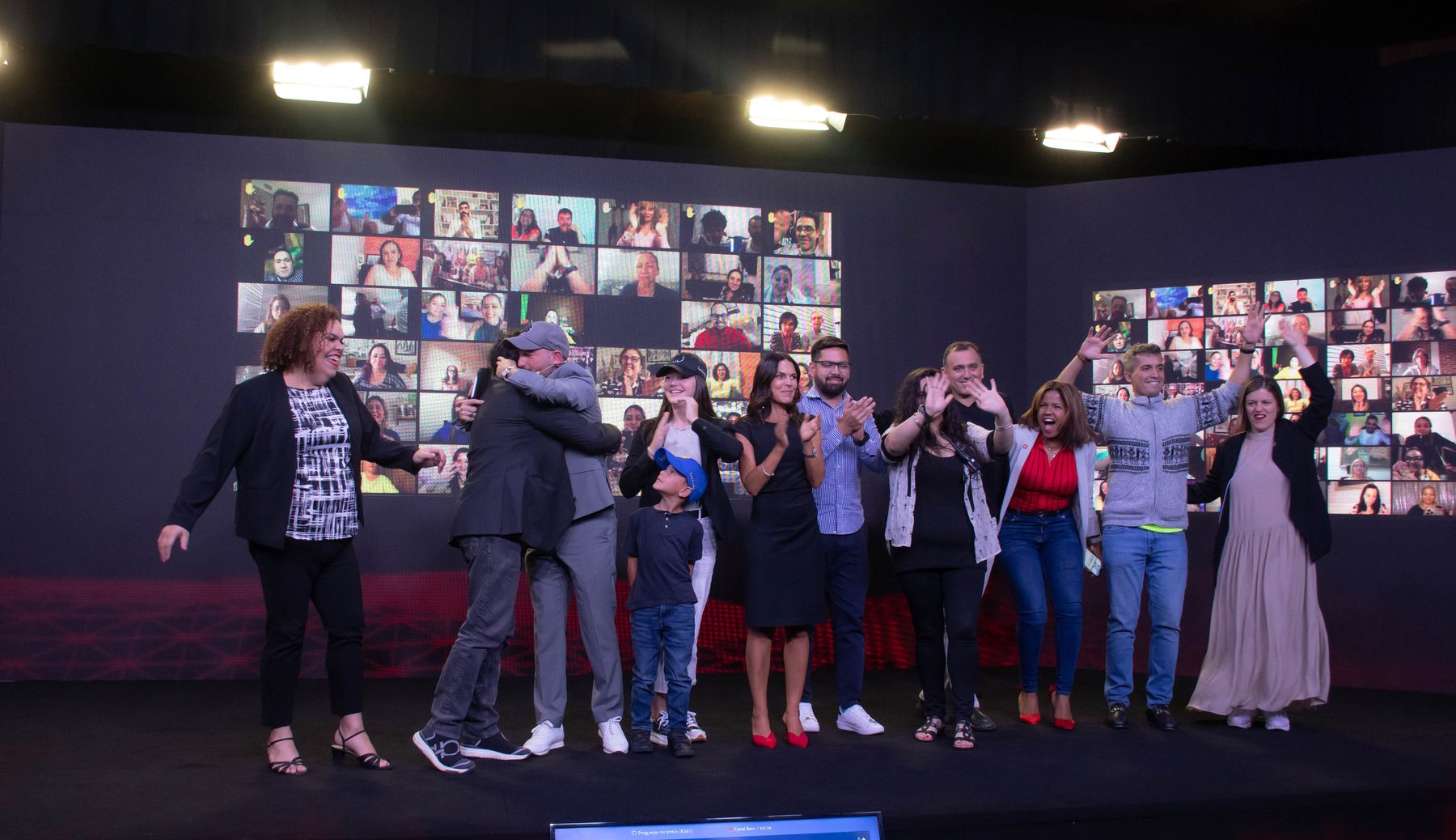 Celebración en el escenario de la Cumbre, con abrazos y aplausos frente al muro LED.