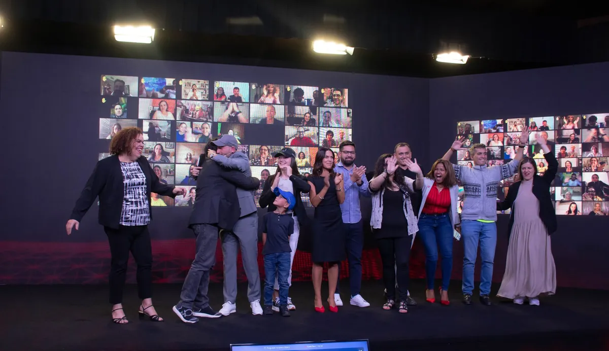 Celebración en el escenario de la Cumbre, con abrazos y aplausos frente al muro LED.