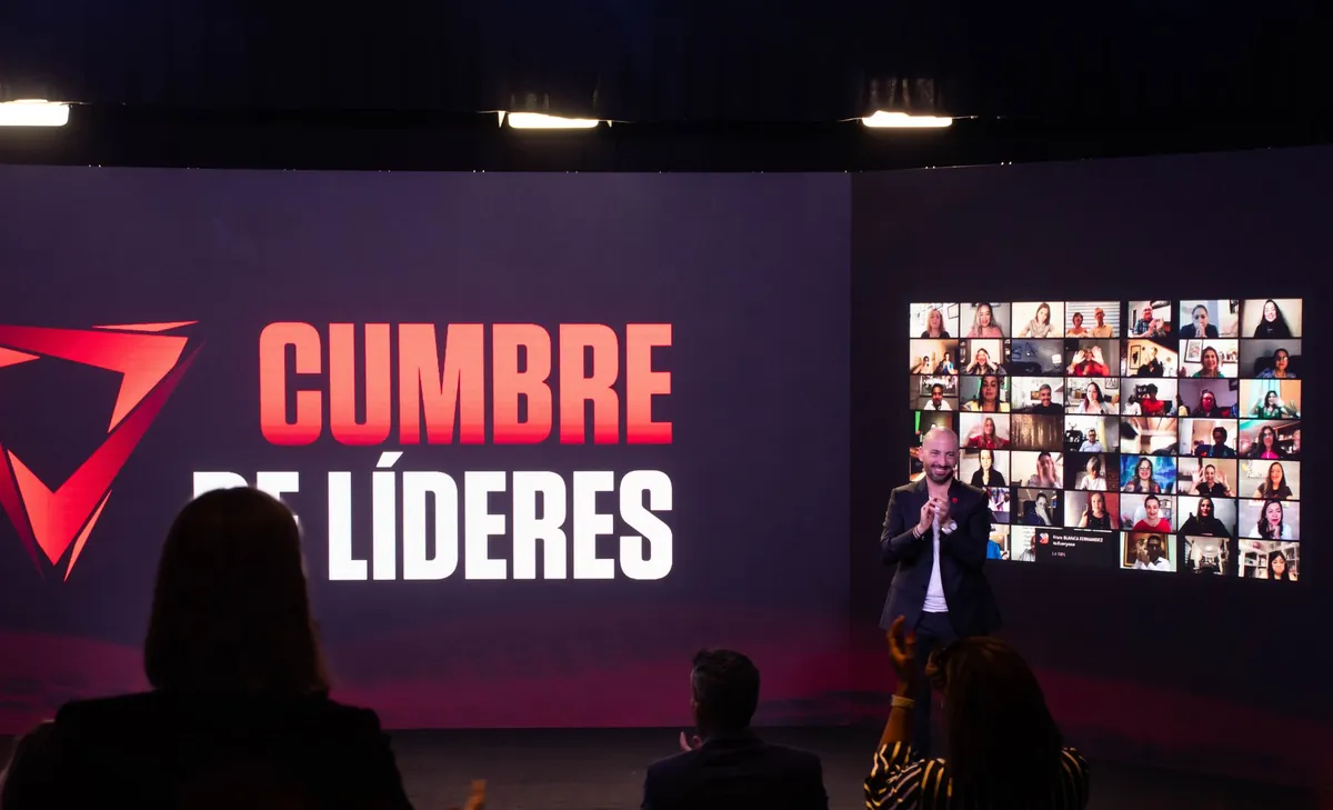 Jaime Lokier aplaudiendo en el escenario frente al muro LED con la marca Cumbre de Líderes.
