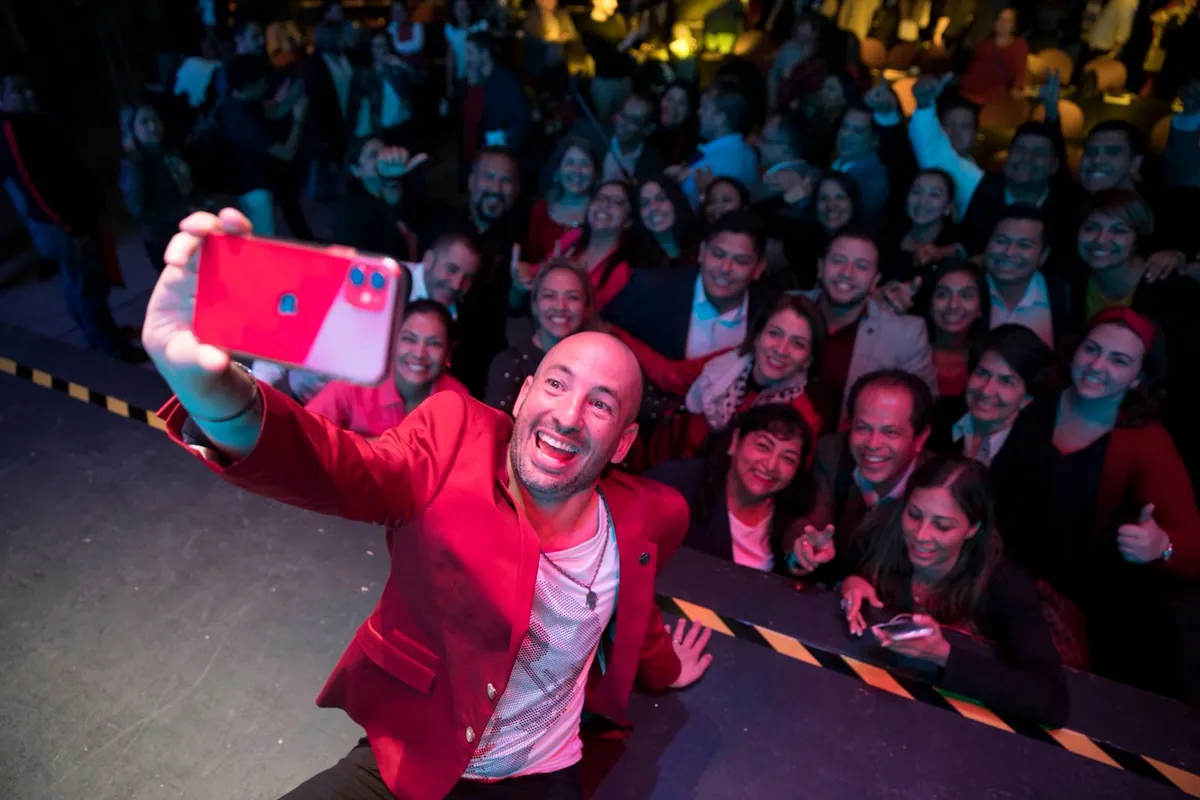 Jaime Lokier tomándose una selfie desde el escenario con el público de la Cumbre detrás.
