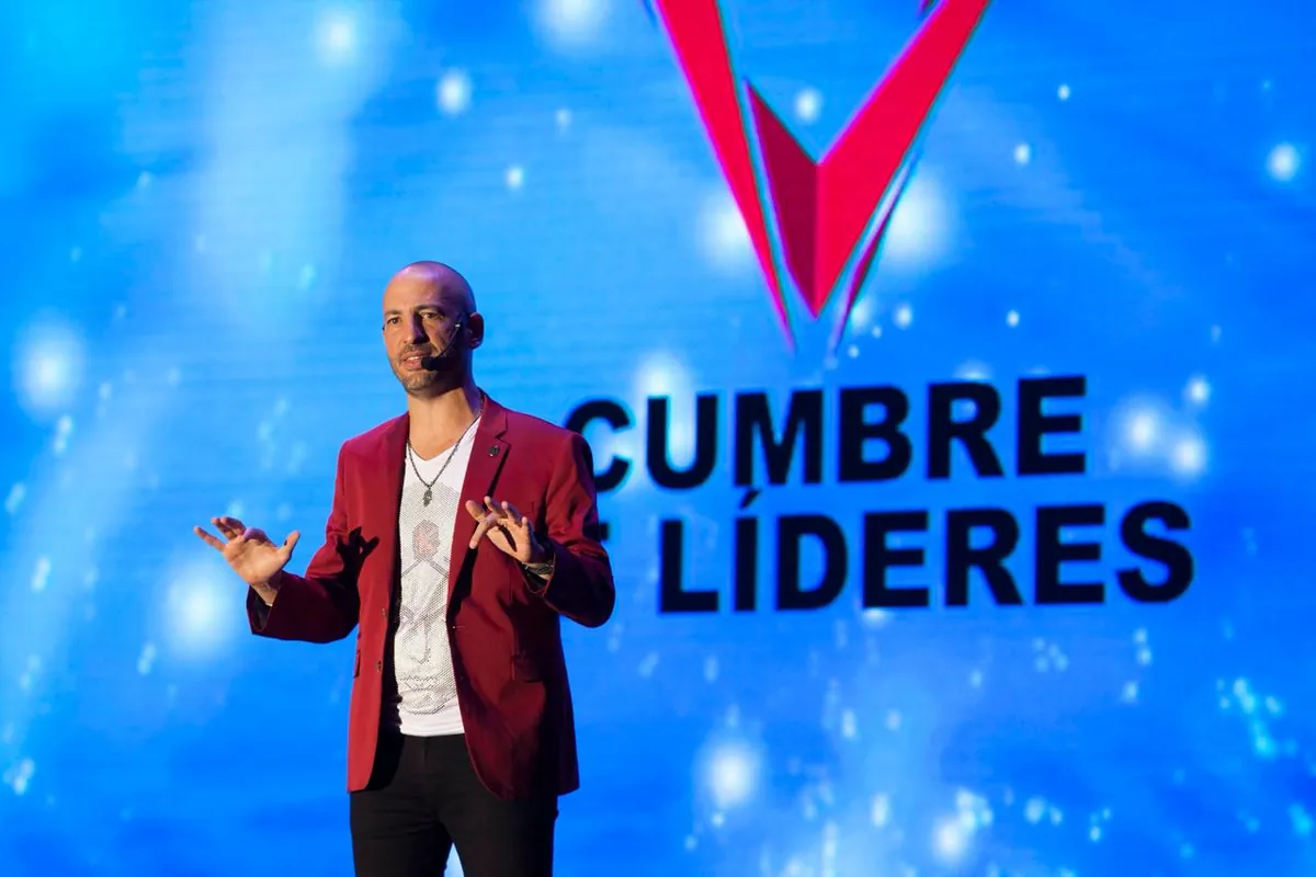Jaime Lokier hablando en el escenario frente a la pantalla gigante con el logo de Cumbre de Líderes.