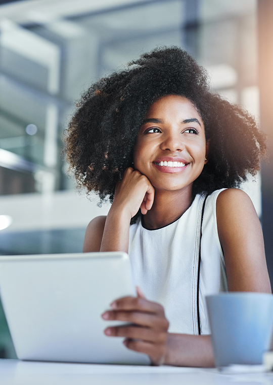 Business professional smiling while working on a tablet