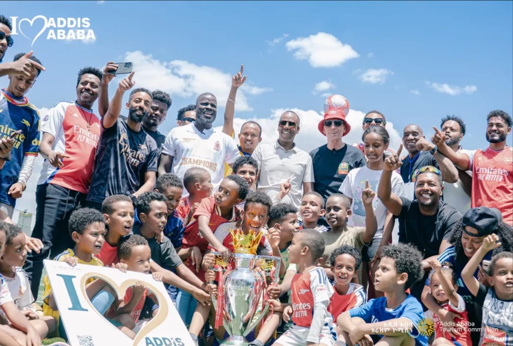 Young players and coaches celebrating with the Premier League trophy in Addis Ababa