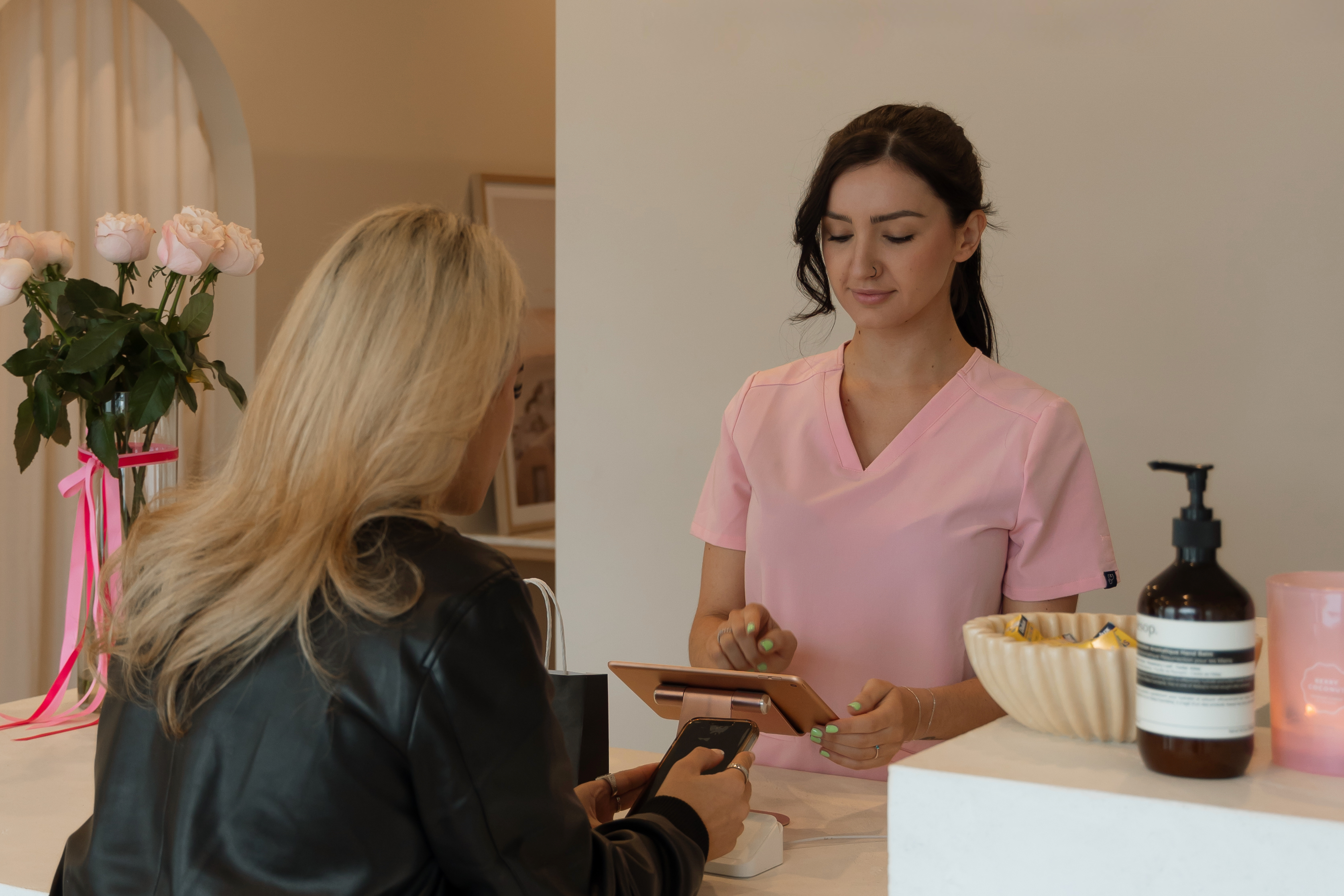 A client tapping to pay at the NDI Cosmetic Nurse reception counter
