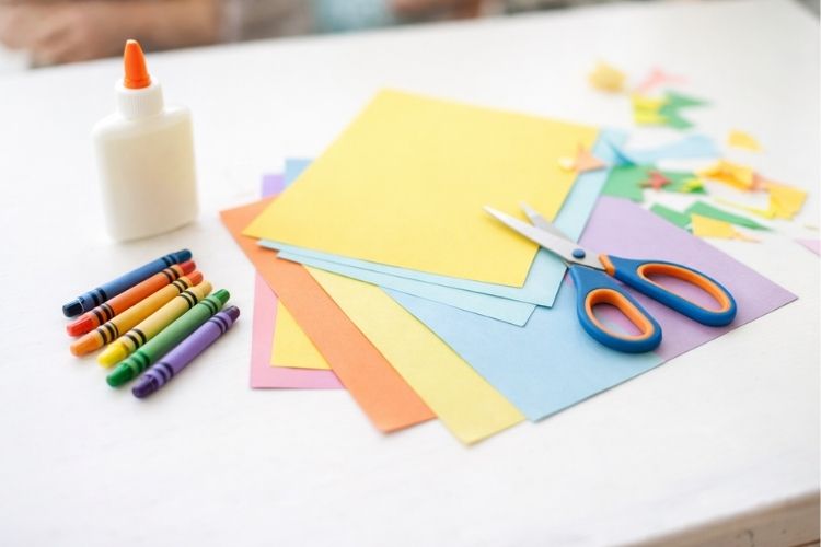 Crayons and coloured paper for a screen-free craft activity