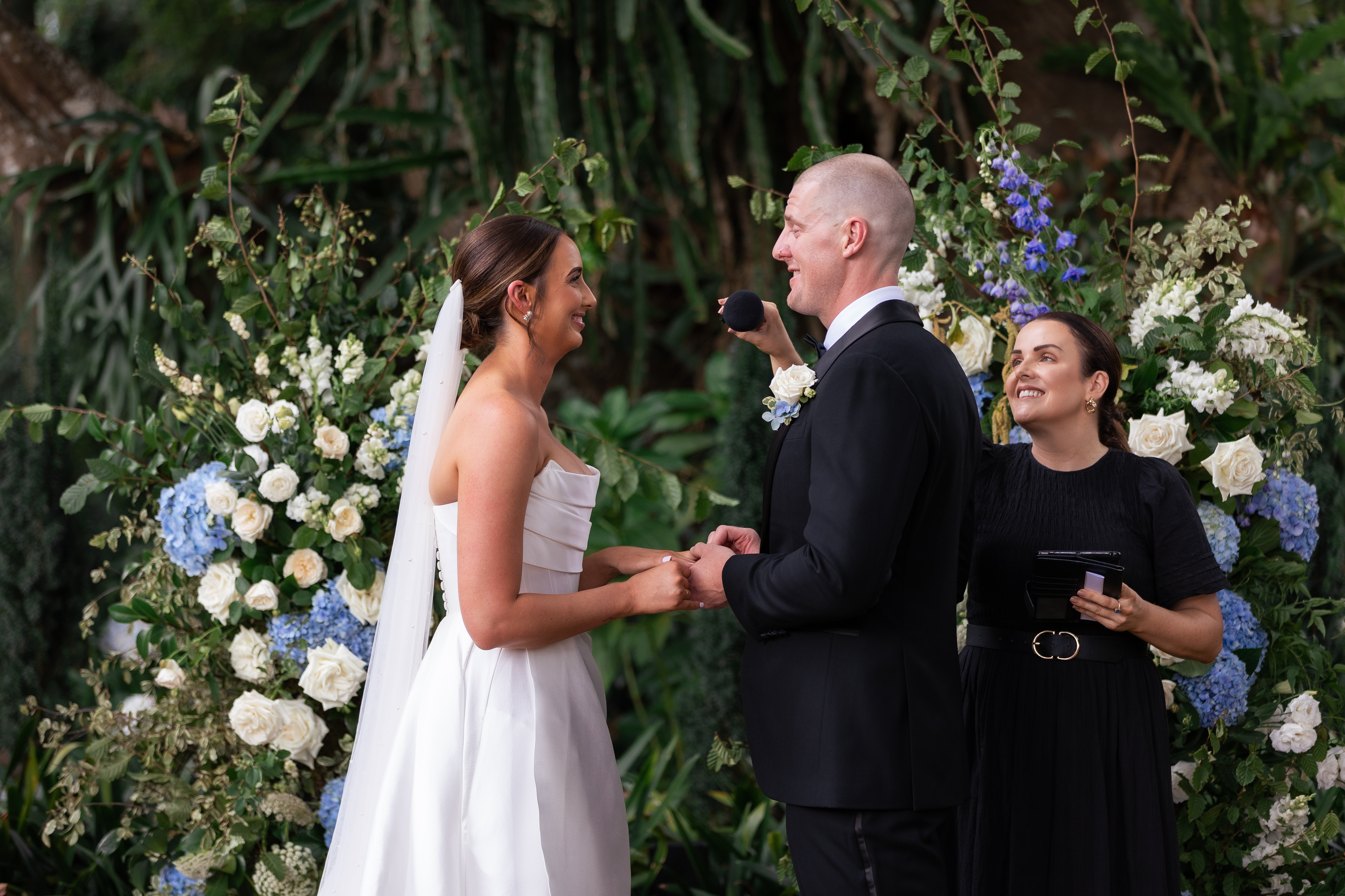 Danielle laughing with a couple at their reception