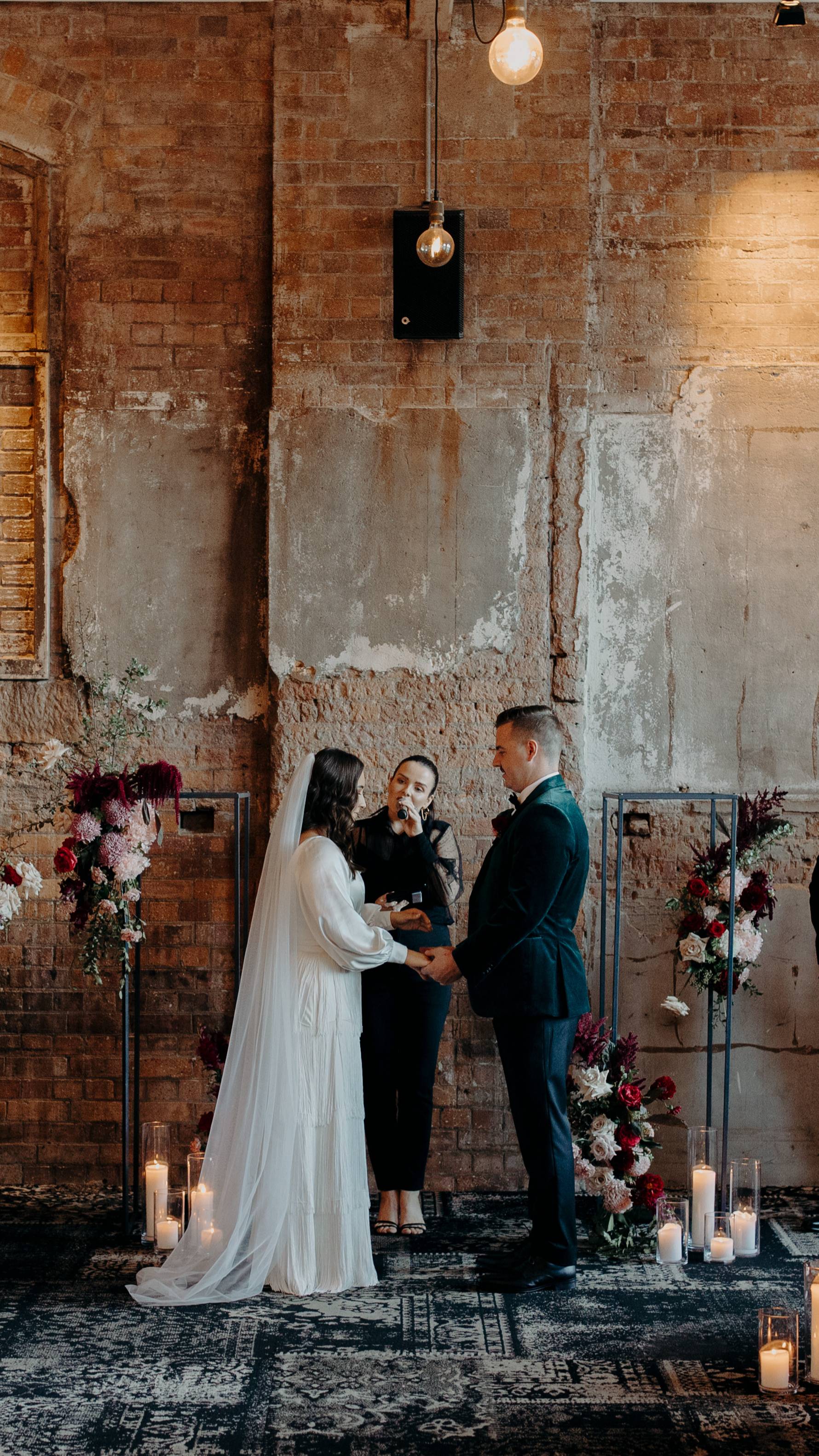 Danielle marrying a couple in a candlelit warehouse ceremony