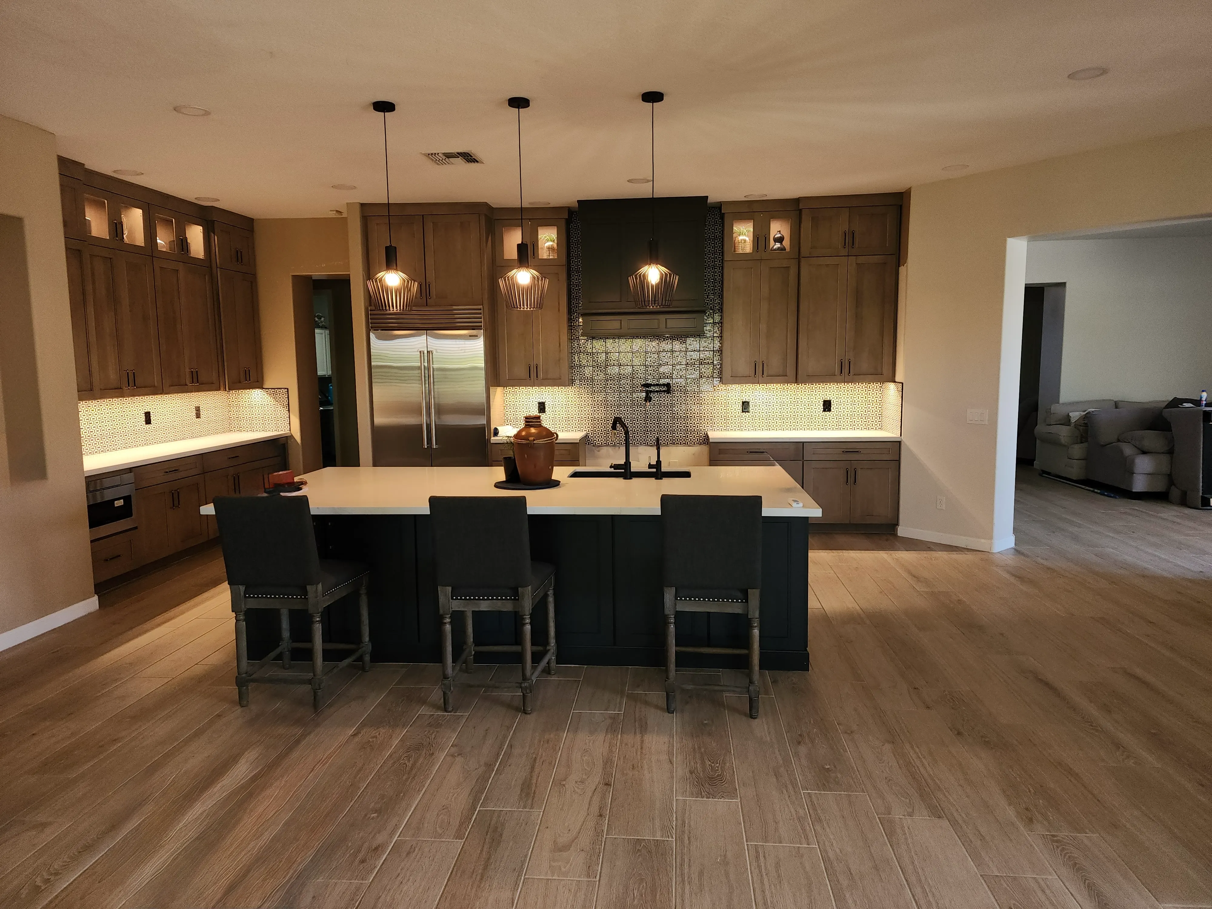 Kitchen pendant lights and illuminated cabinetry installed by Bright Light Electric