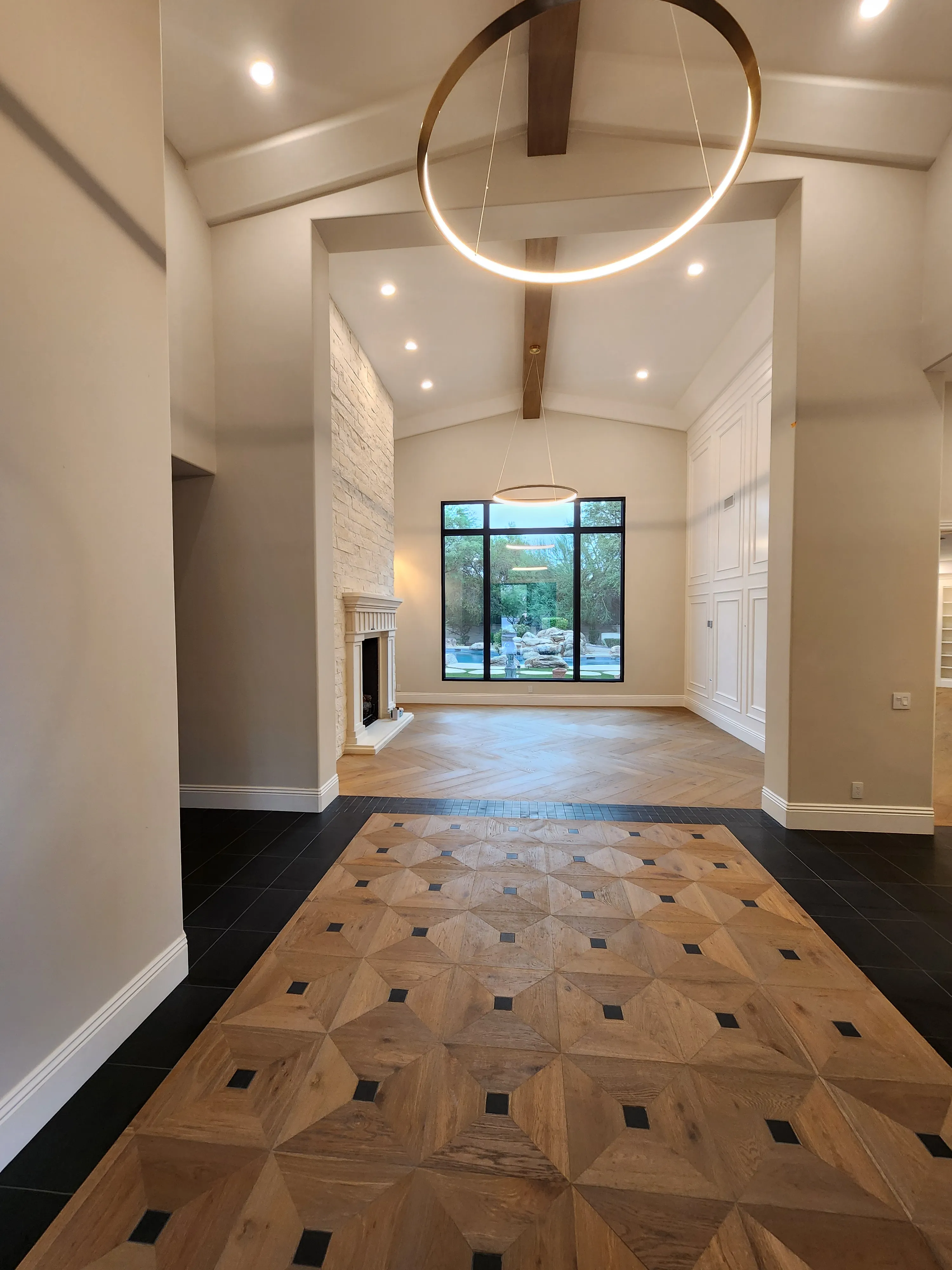 Large circular statement light and recessed lighting in a high-ceiling room