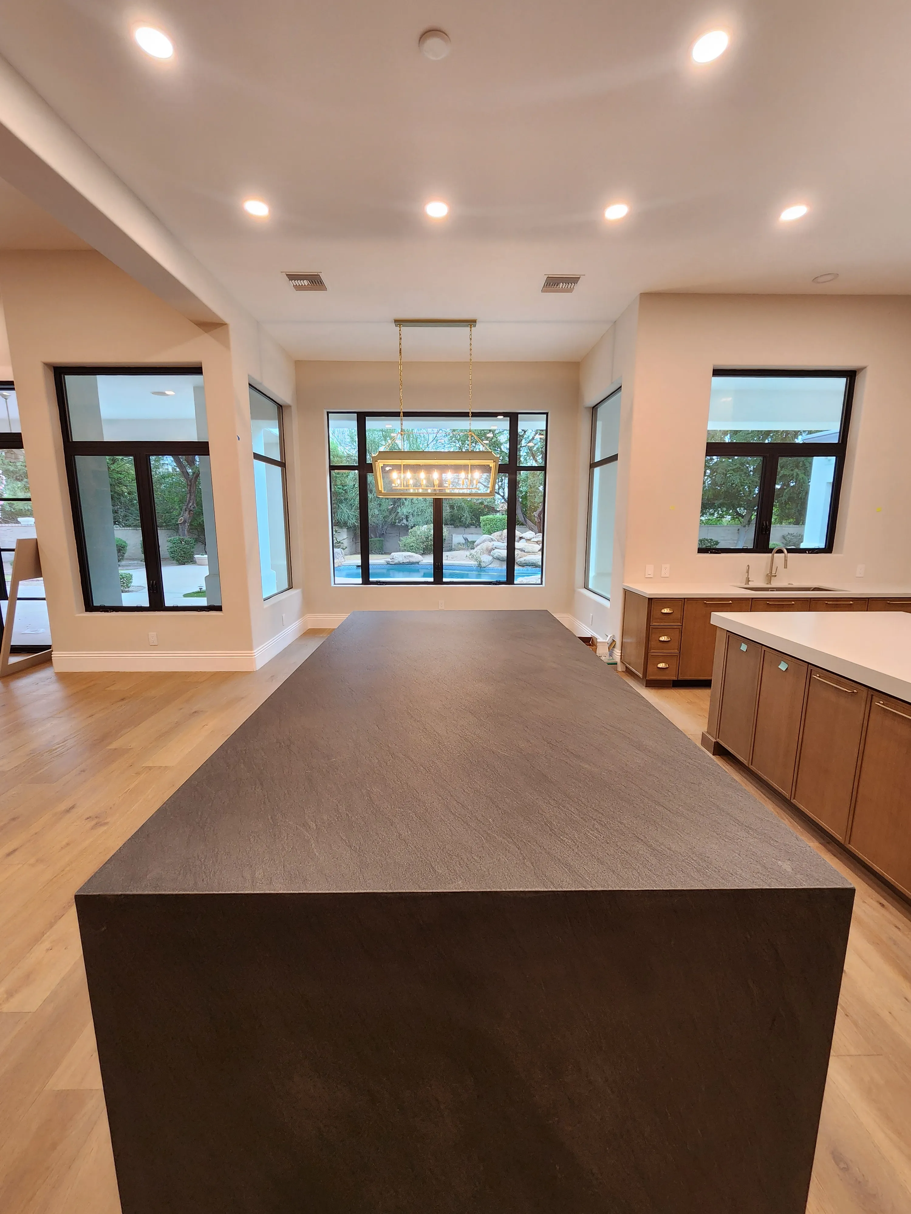 Kitchen with recessed ceiling lights and a decorative island fixture