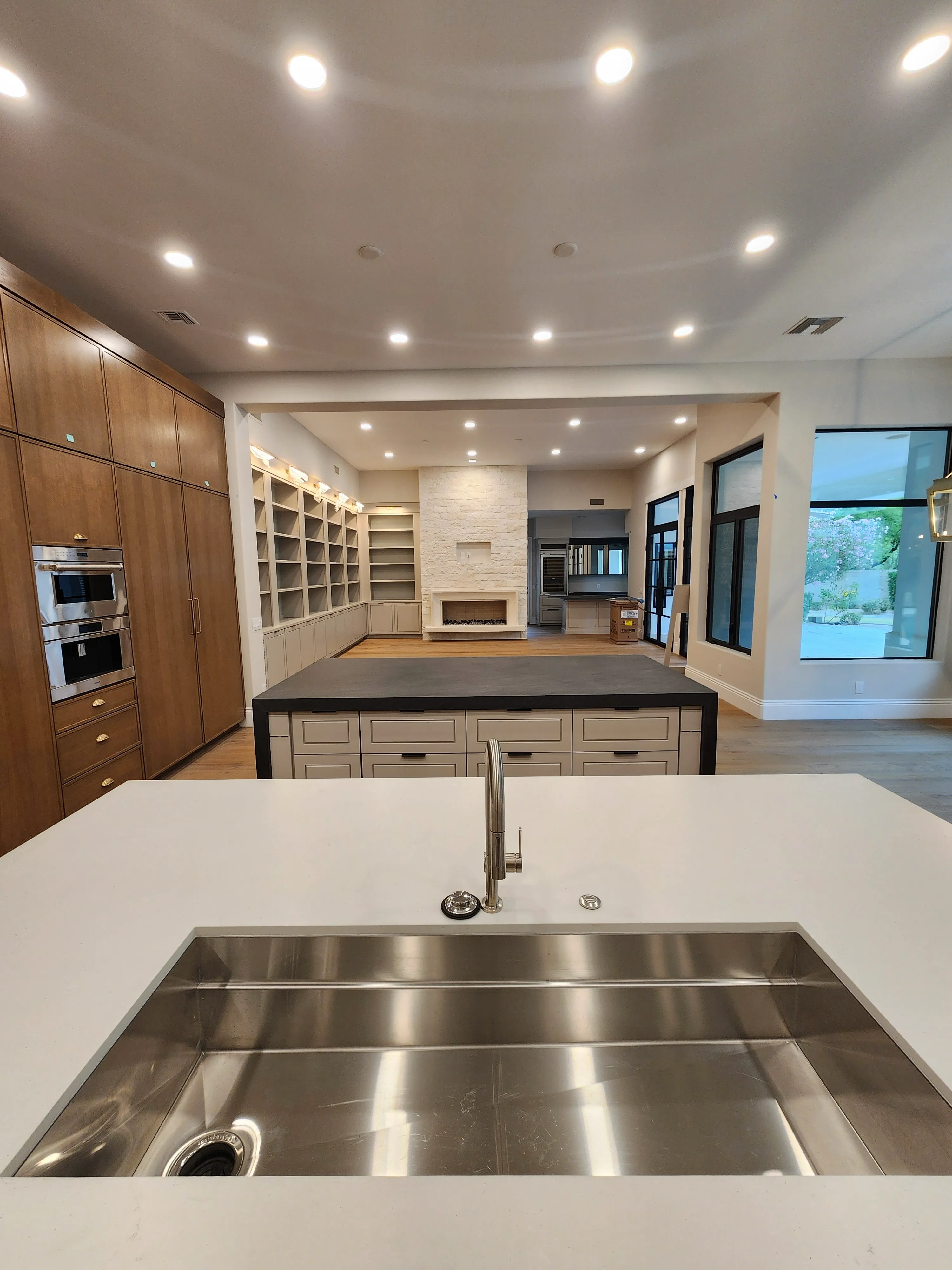 Completed kitchen and living space with extensive recessed lighting