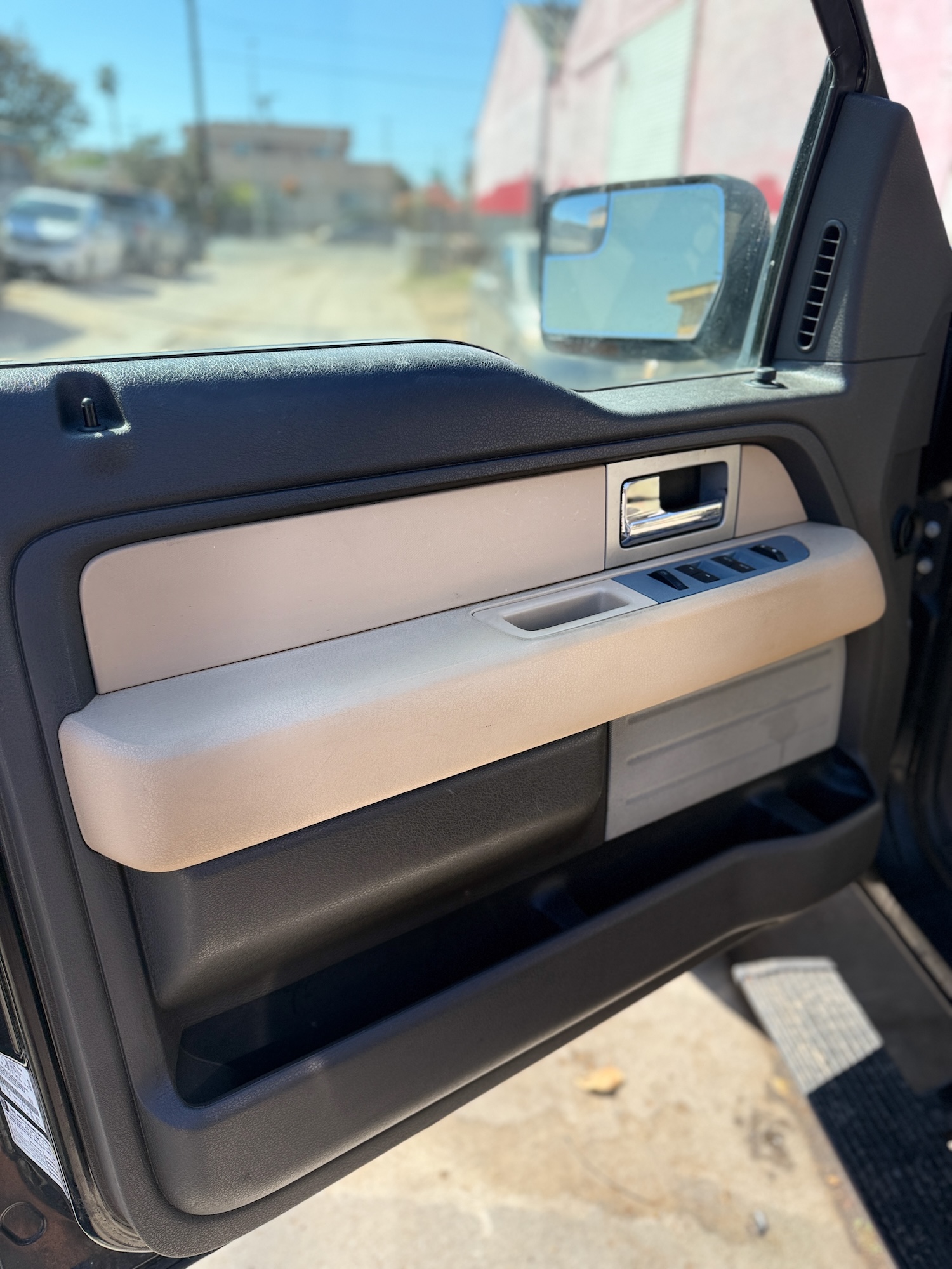 potless tan and black car door panel after deep interior detailing and sanitizing.