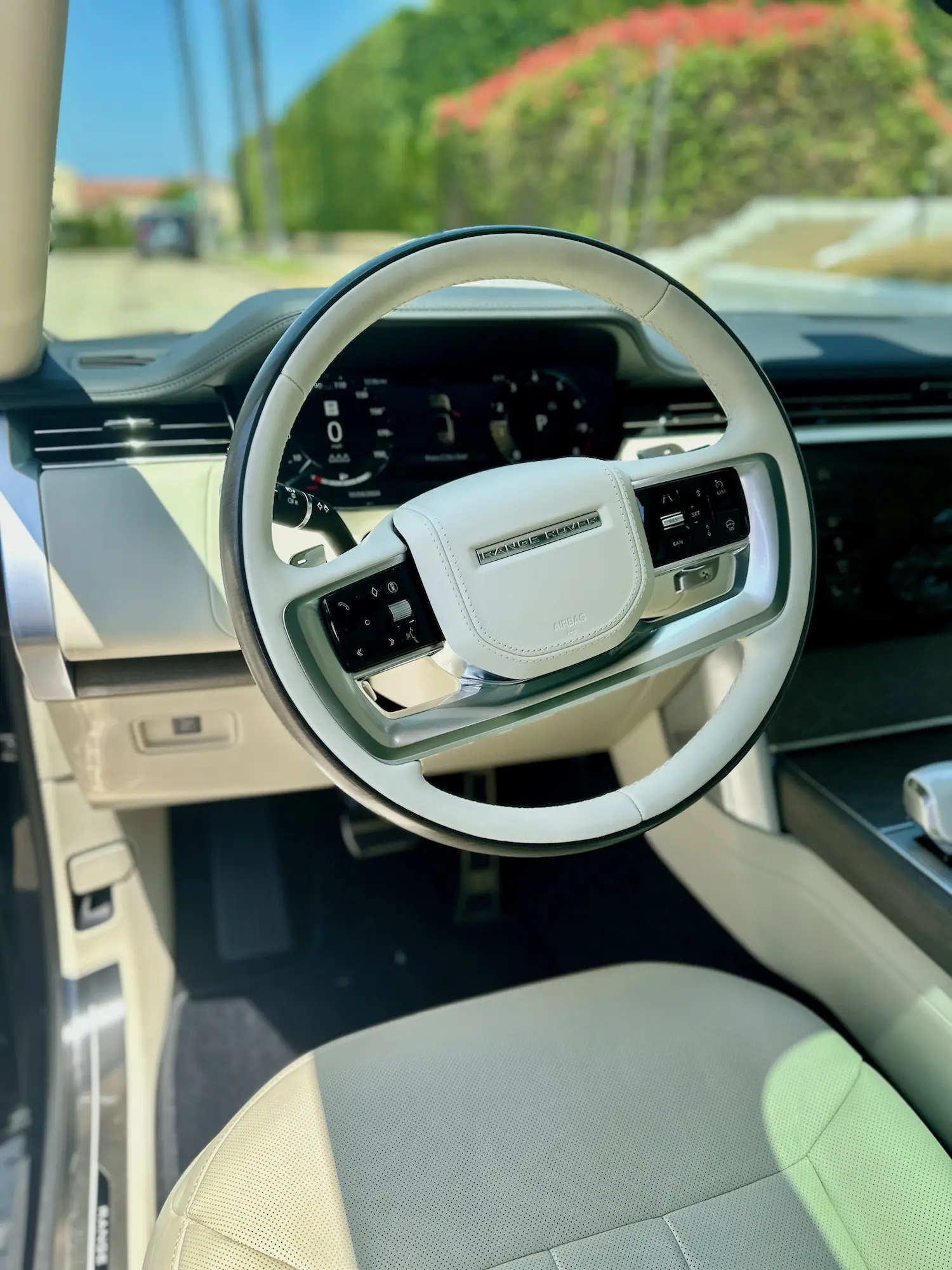 Pristine white leather Range Rover interior following a deep clean and UV protectant treatment, highlighting steering wheel and dashboard finish.