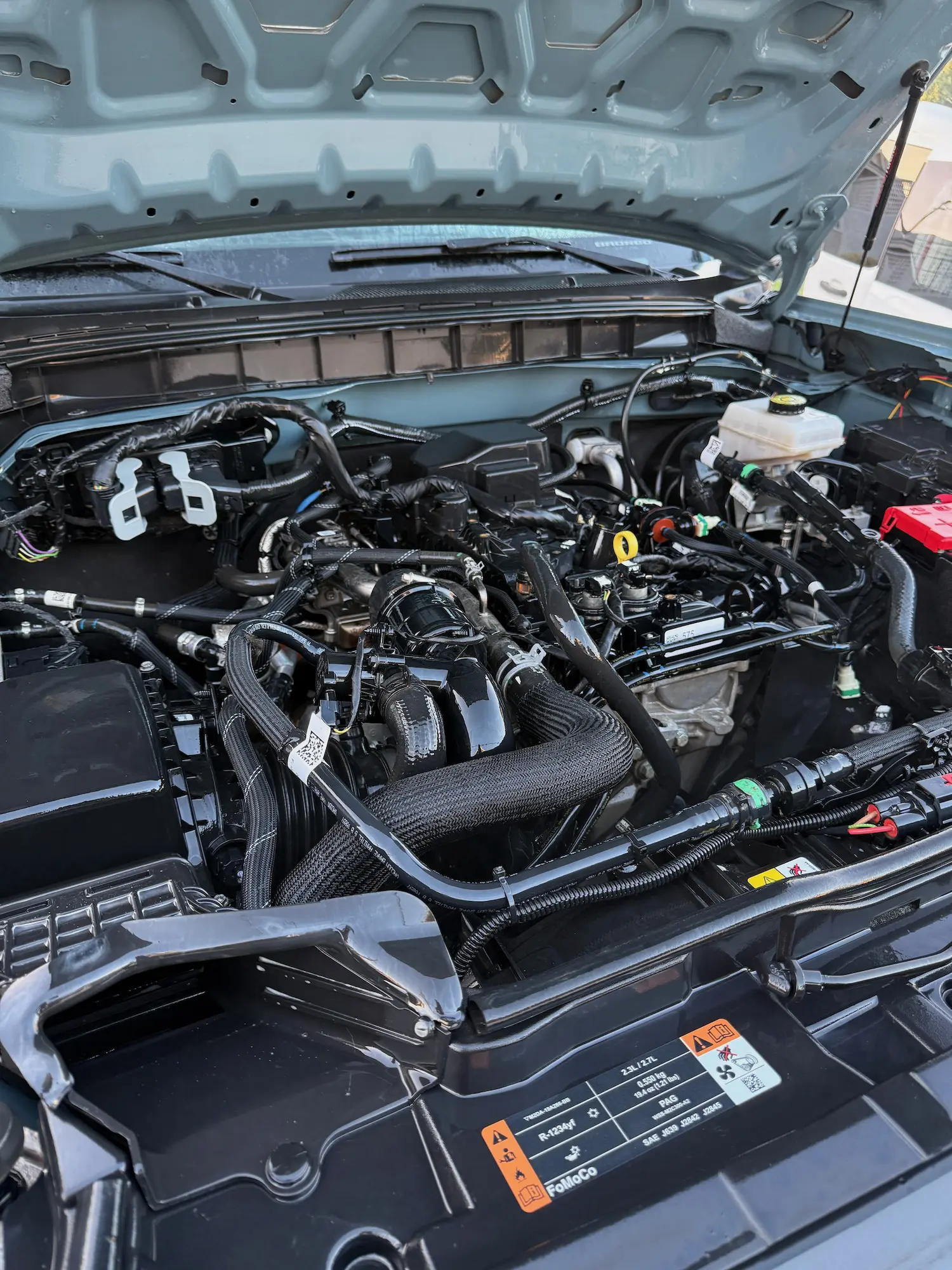Clean engine bay after steam detailing, showing a spotless and polished finish with visible wiring and engine components.