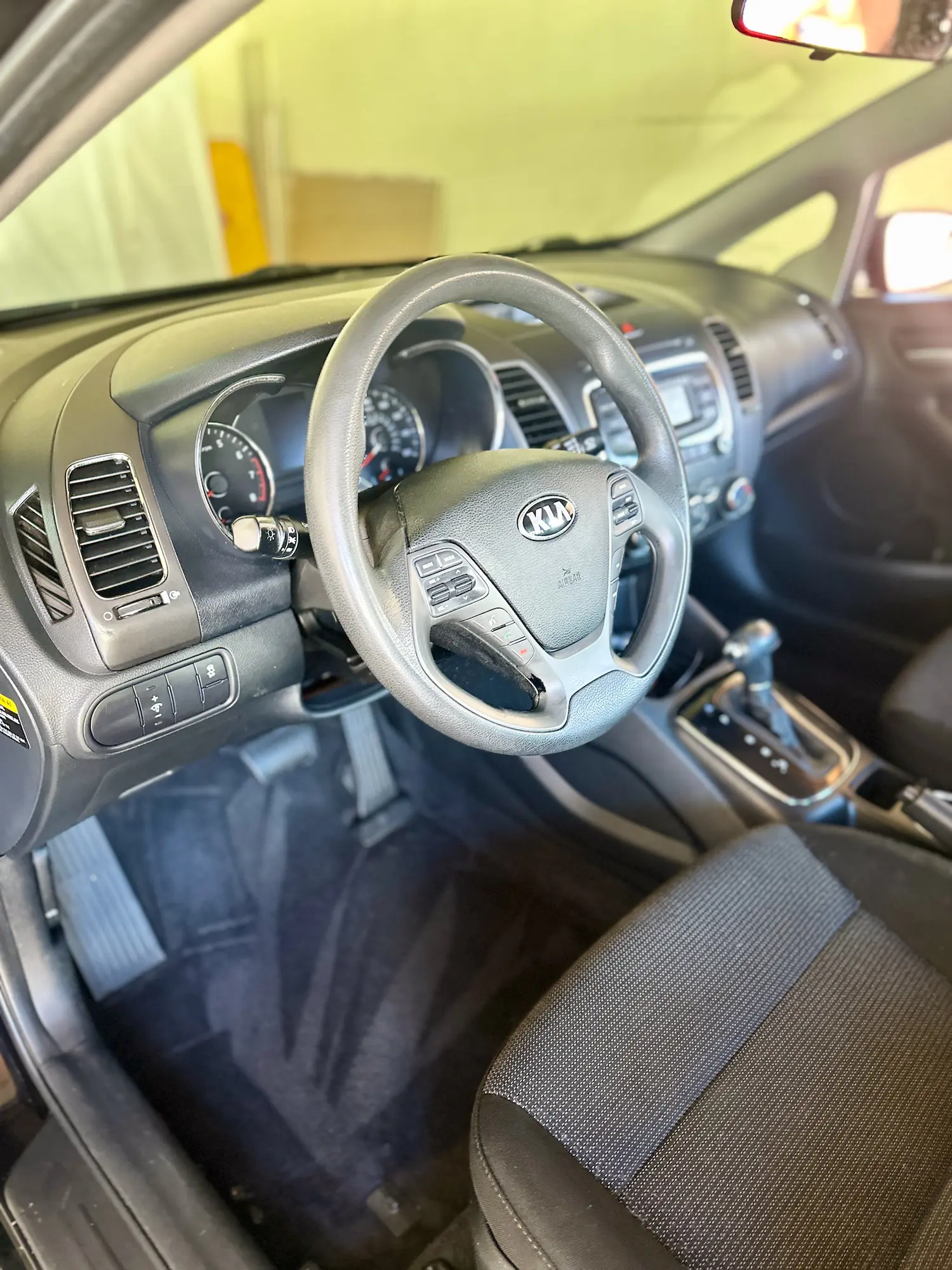 Freshly detailed car interior with clean dashboard, vacuumed carpet, and spotless driver area after full interior detail.