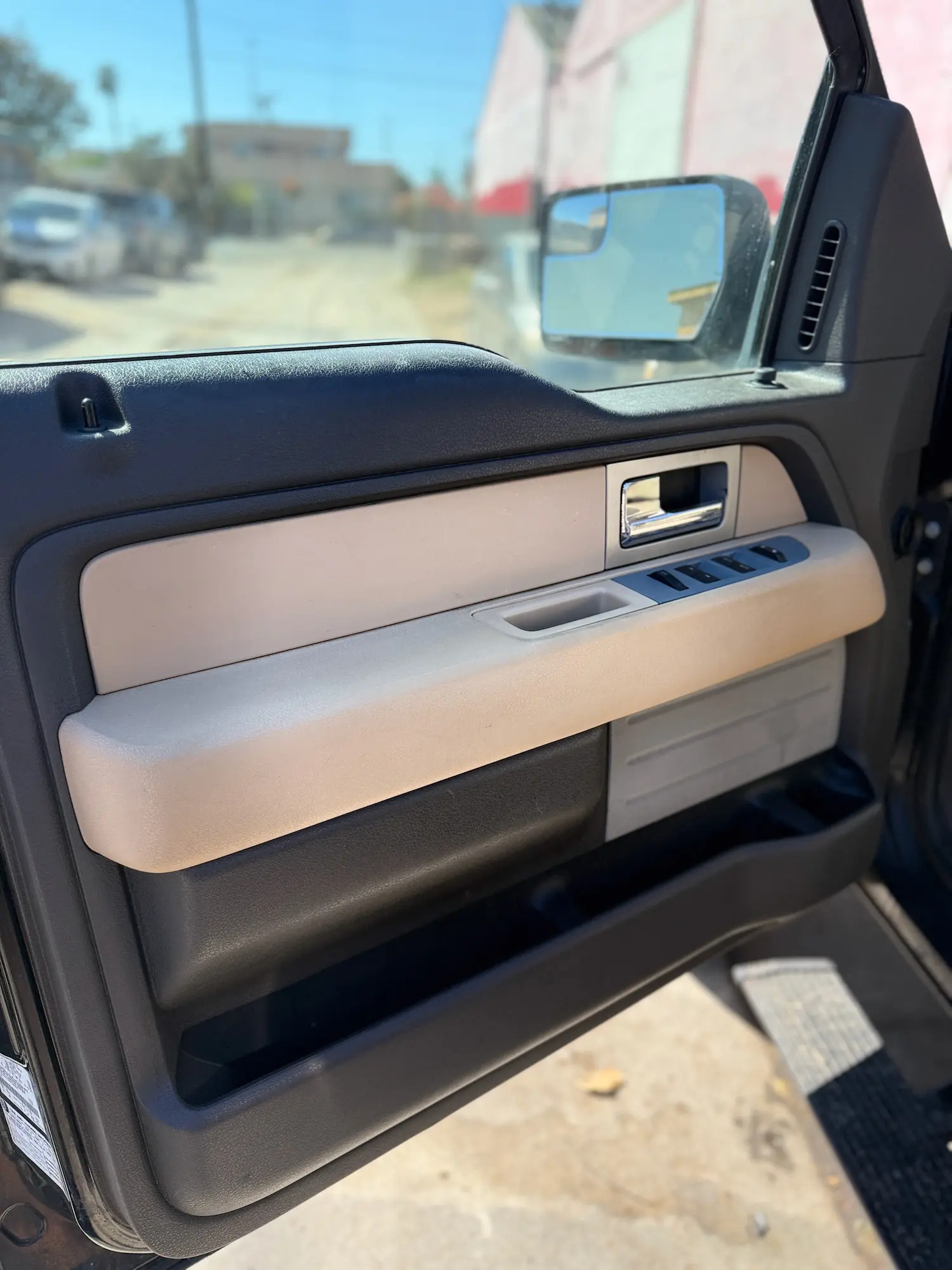 potless tan and black car door panel after deep interior detailing and sanitizing.