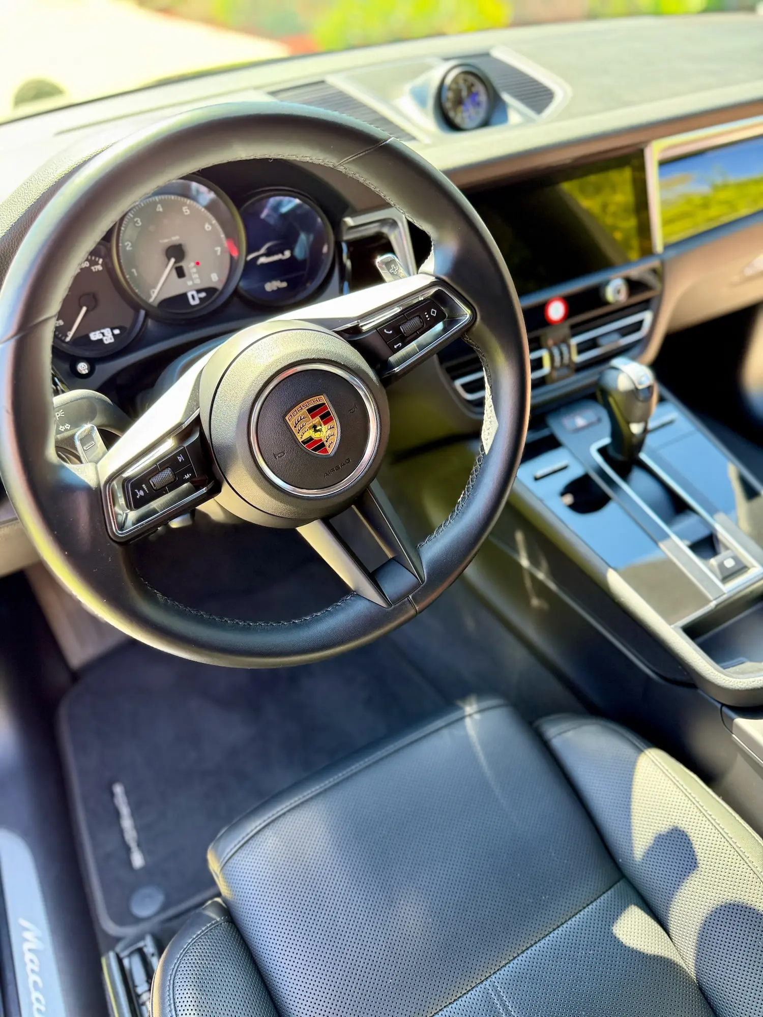 Luxurious Porsche Macan interior featuring detailed steering wheel, gauges, and leather seats post-detail.