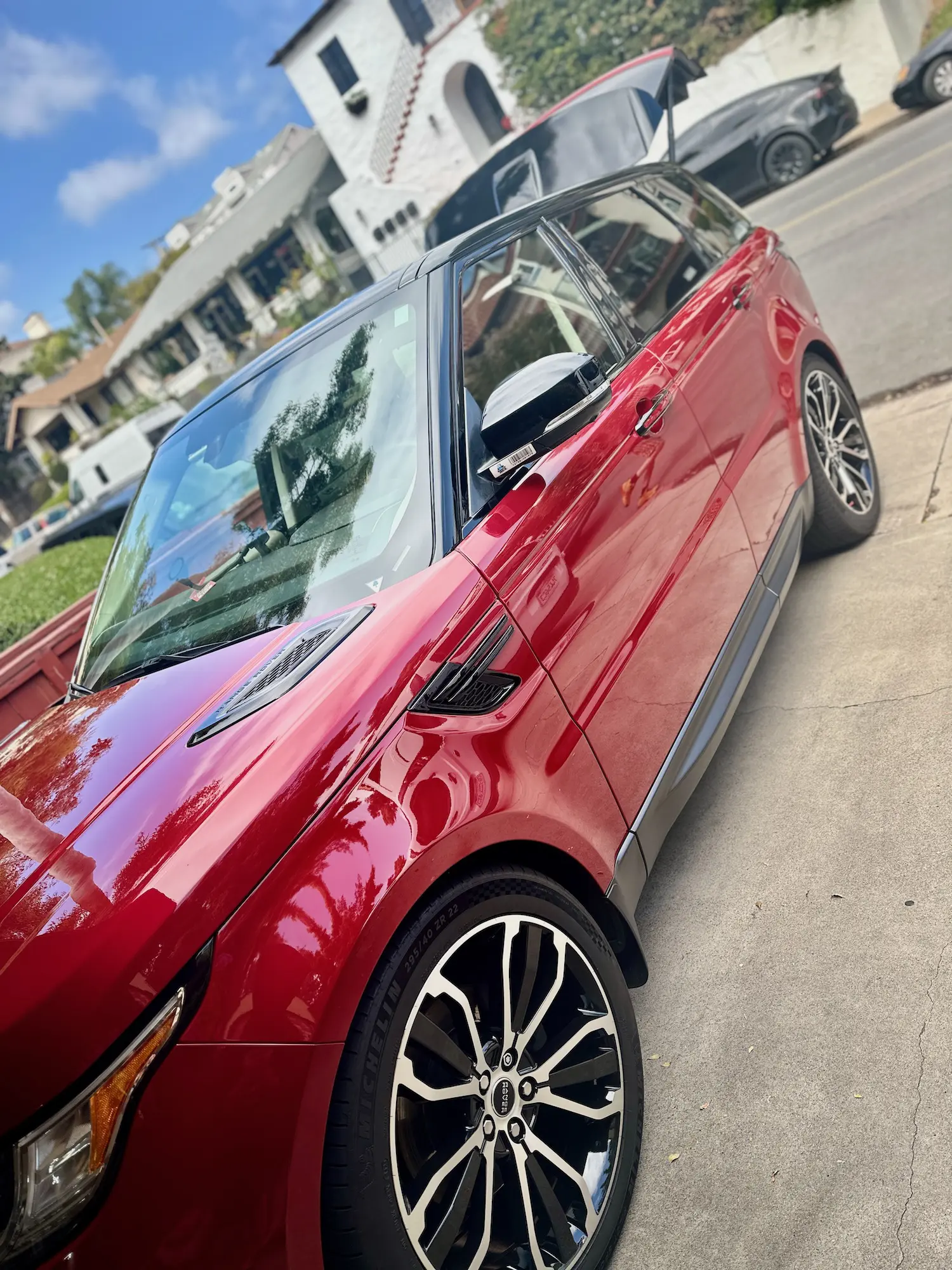 Red Range Rover SUV with polished exterior parked on driveway after exterior auto detail.