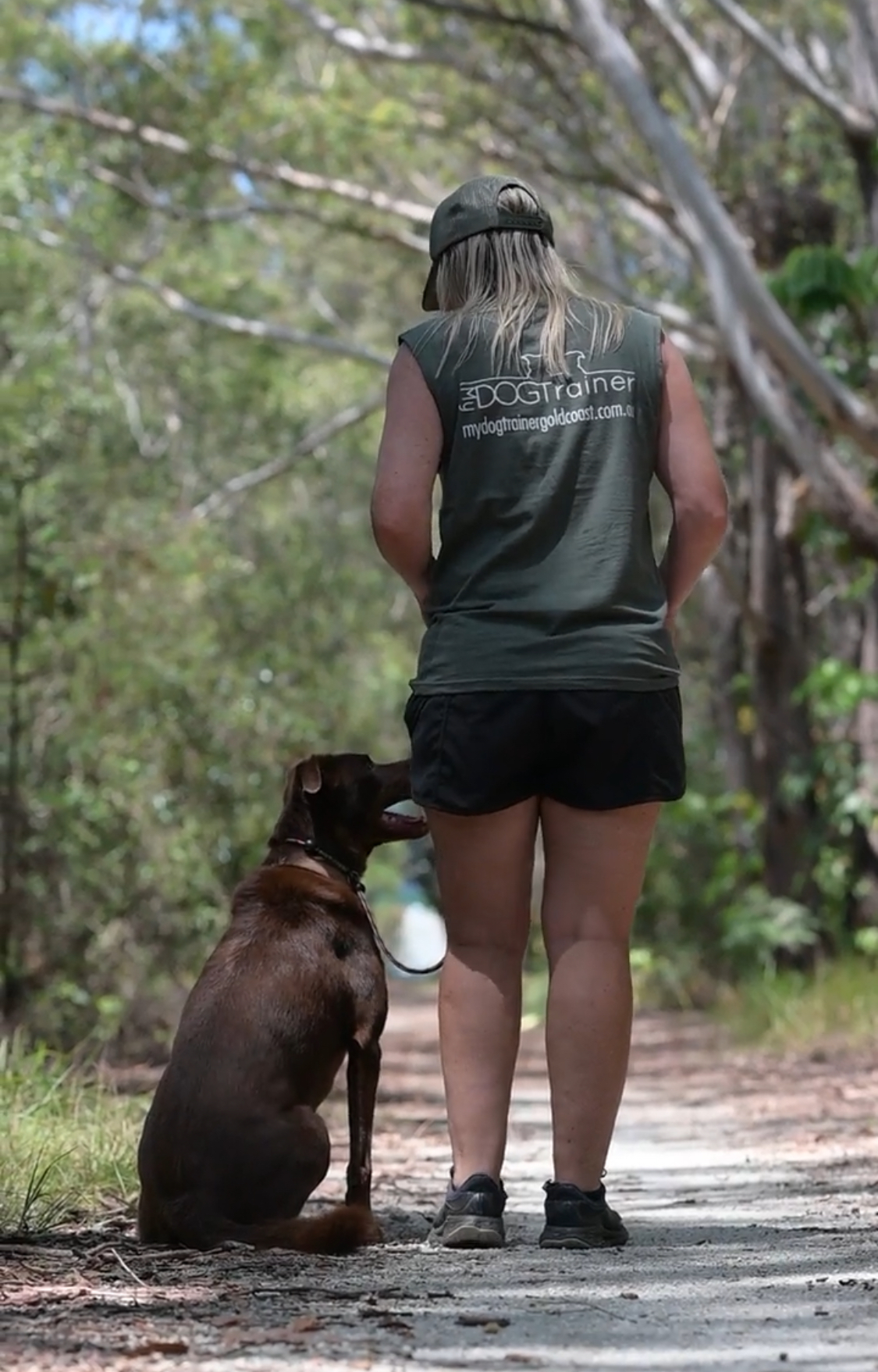 Trainer walking small white dog