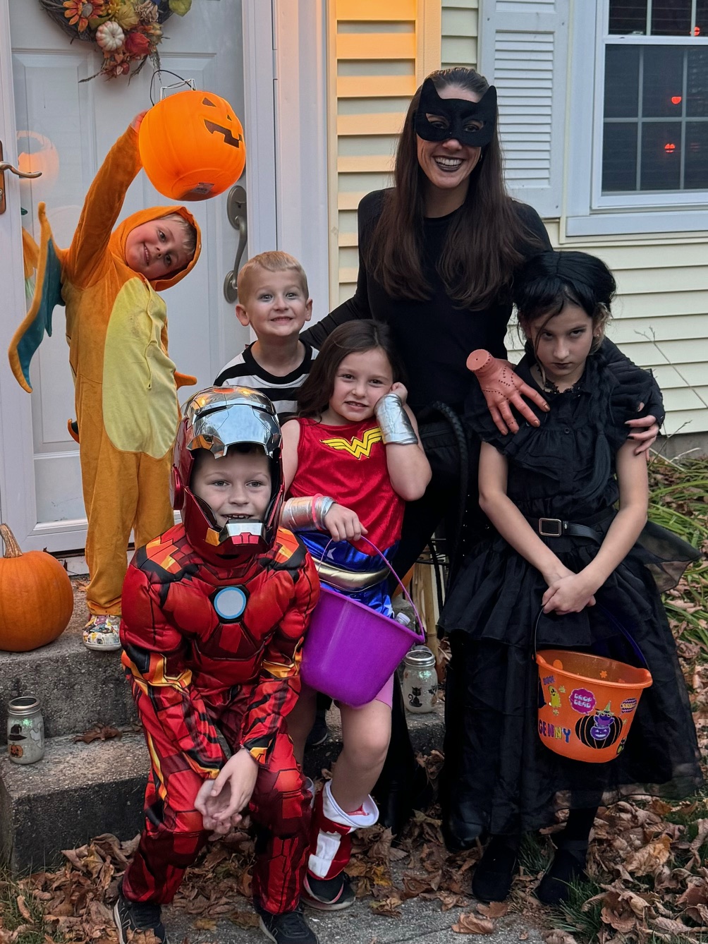 Kellie Hamilton with kids in Halloween costumes holding trick or treat buckets