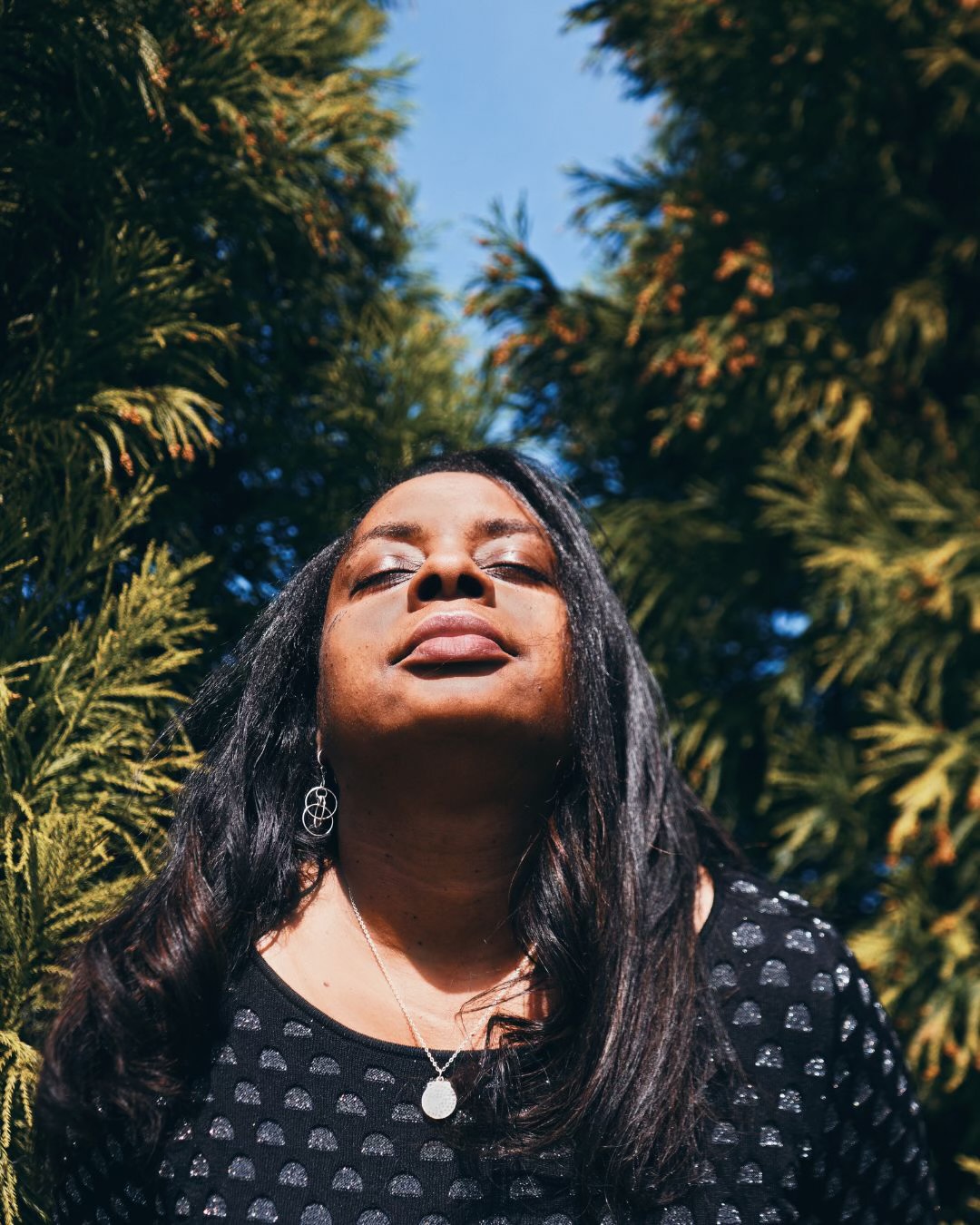 Woman of color basking in sunlight — peace and vitality after Restored
