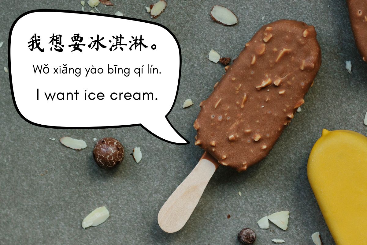 Chocolate ice cream bar on a stick with almonds beside a yellow popsicle and nuts. Speech bubble reads "I want ice cream" in simplified Chinese characters, pin yin and English.