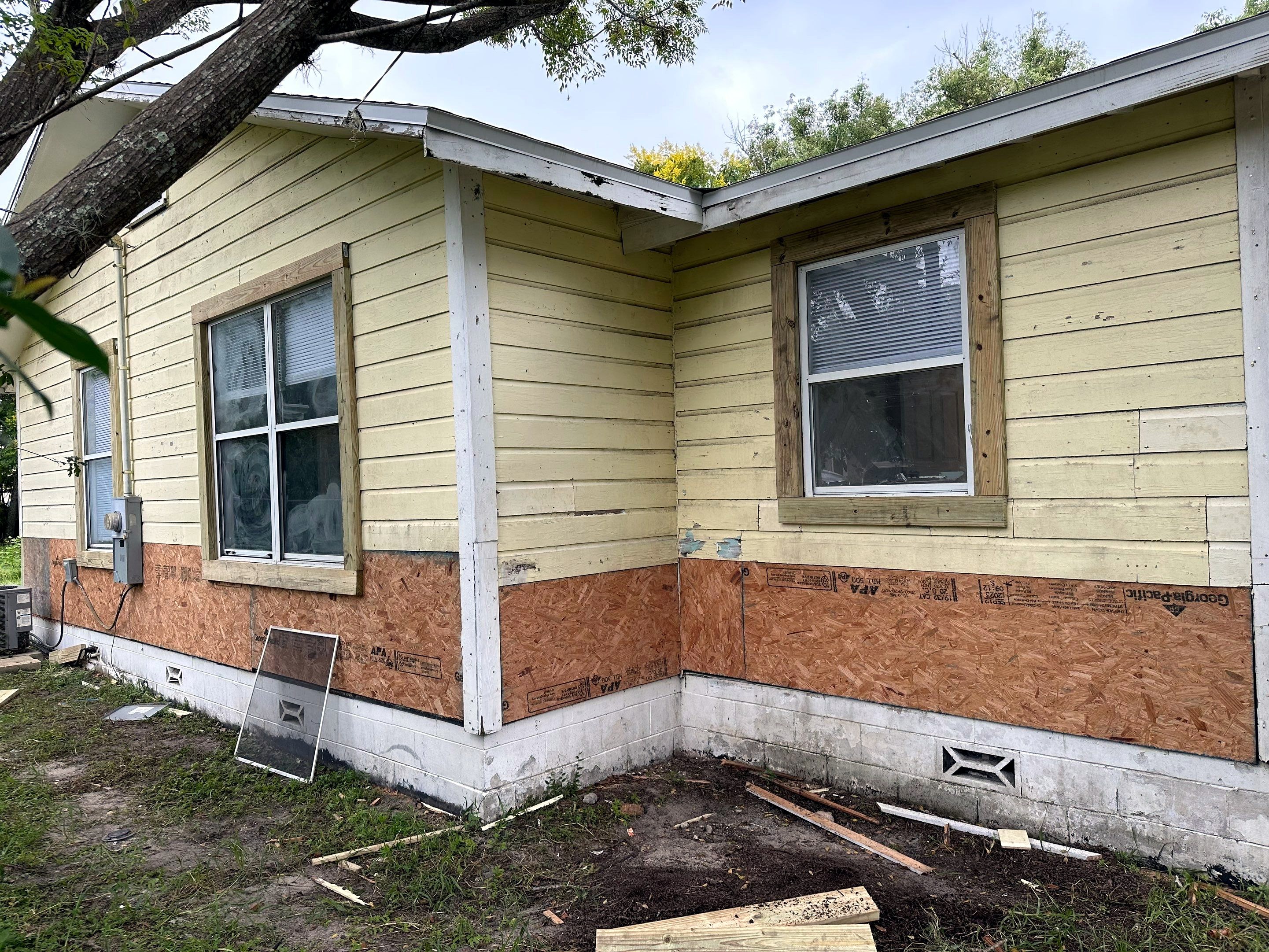 Before: house with rotted underlayment wood exposed after siding removal