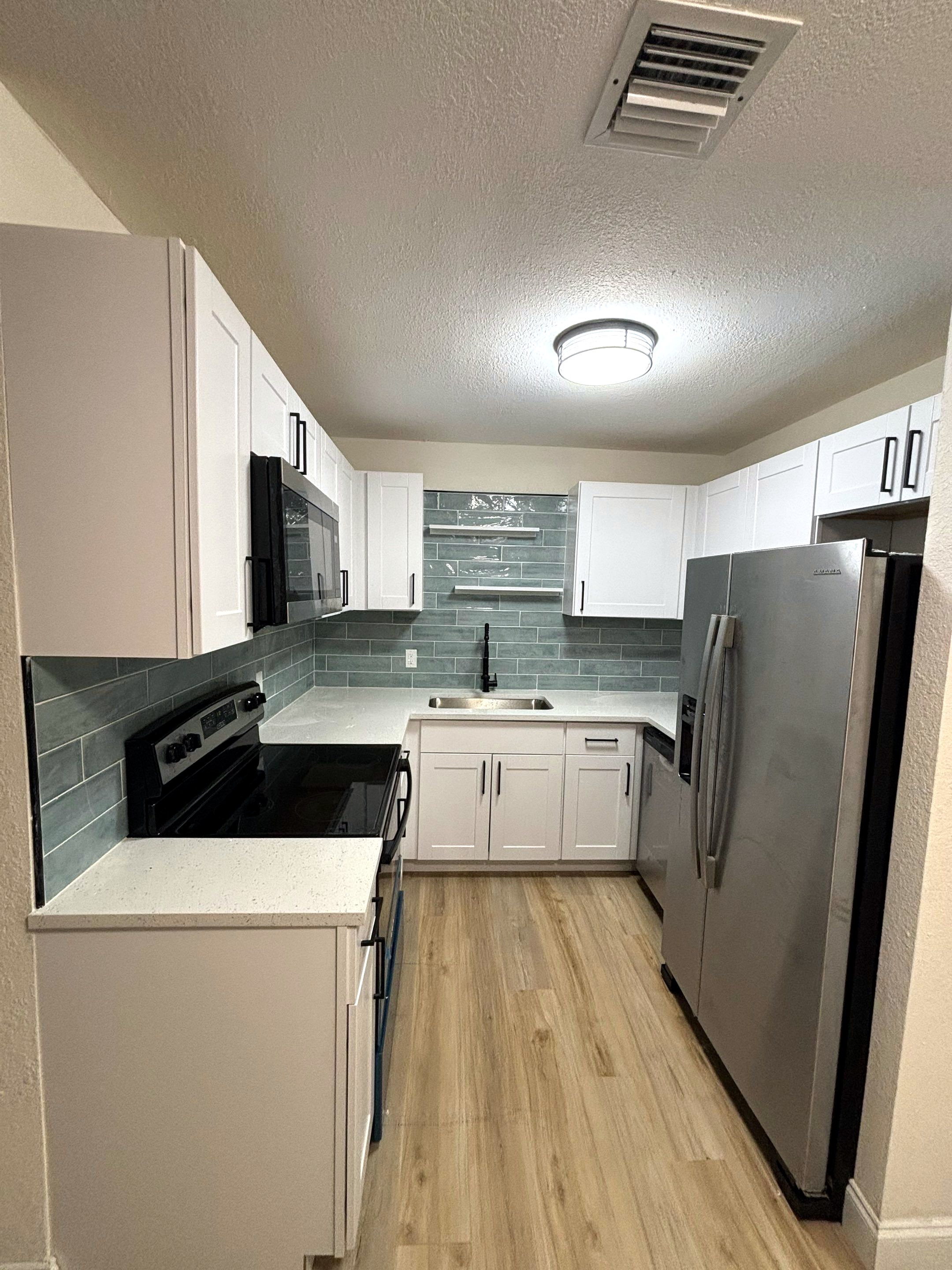 After: rip and replace kitchen with quartz top, soft close, black handles and stainless steel appliances