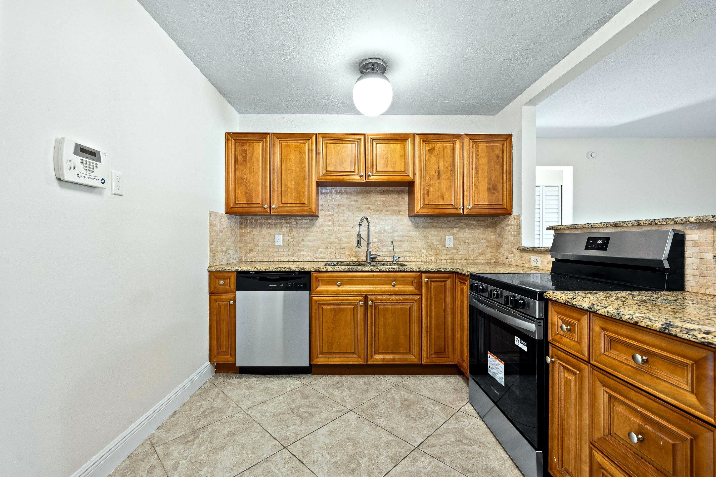 Before: dated oak kitchen with granite countertops