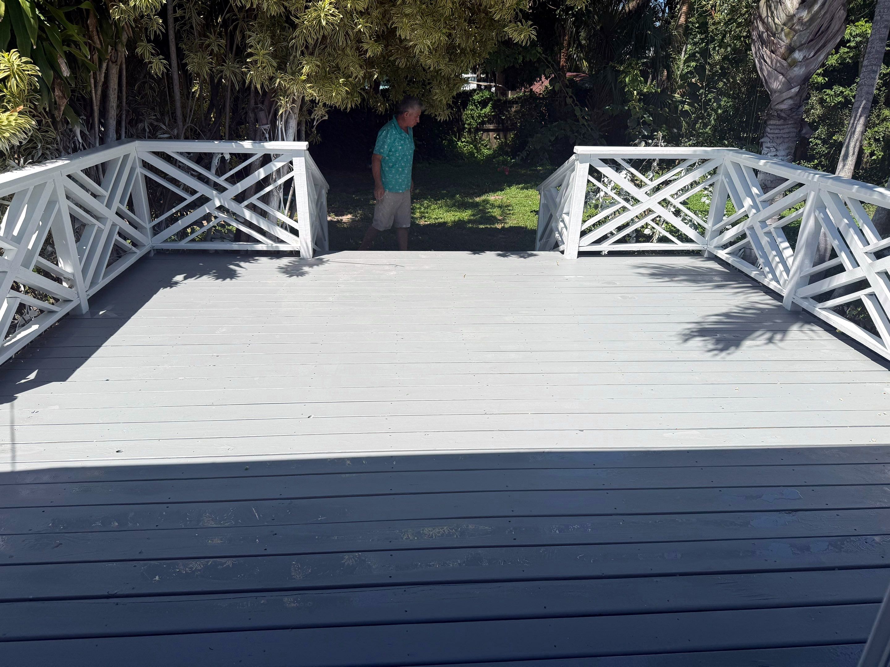 After: deck rebuilt in pressure treated wood, stained and sealed, with white railings
