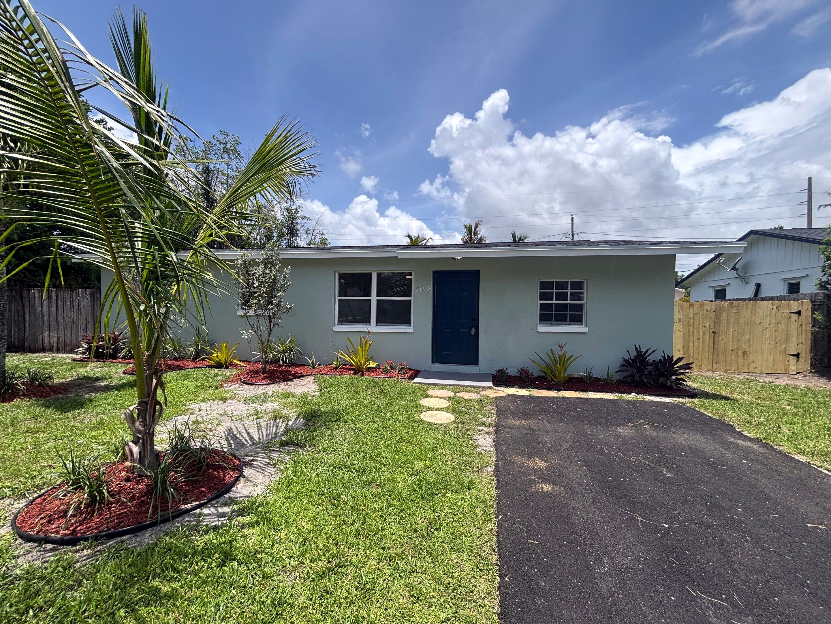 After: pressure washed and painted house with a landscape package and new asphalt driveway