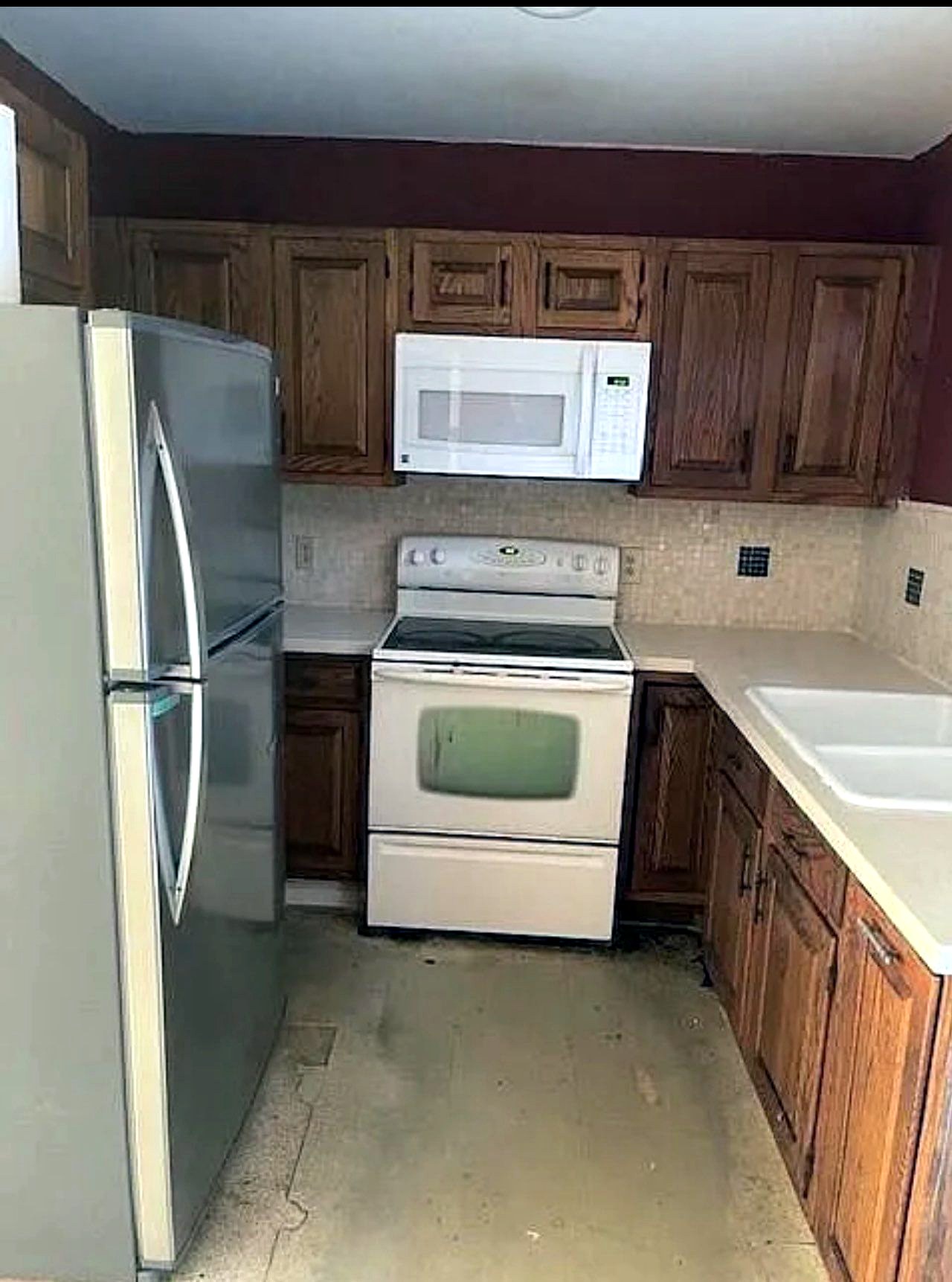 Before: dark oak kitchen with white appliances
