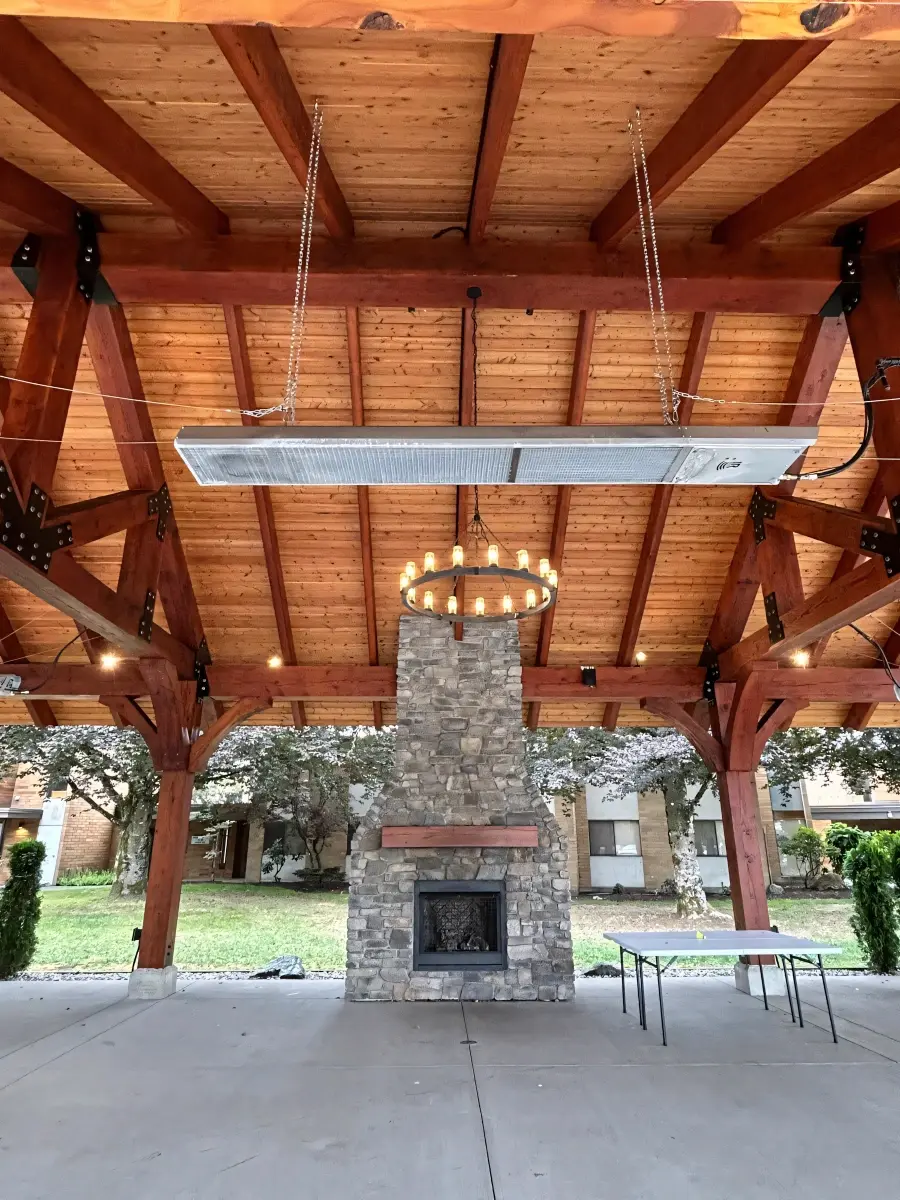 Timber pavilion interior with chandelier and stone fireplace