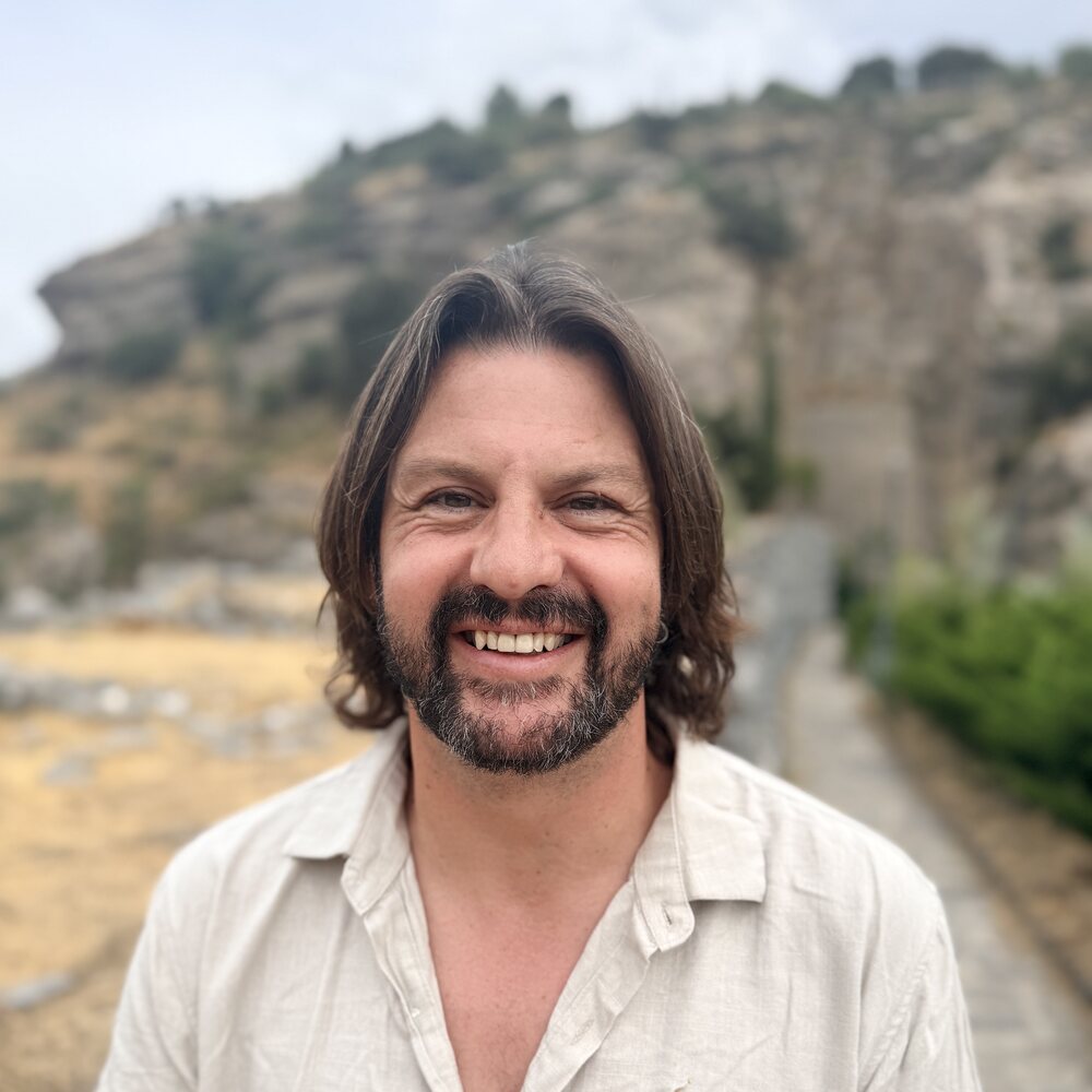 Leon Smith, smiling, in a linen shirt in the hills near Mojácar