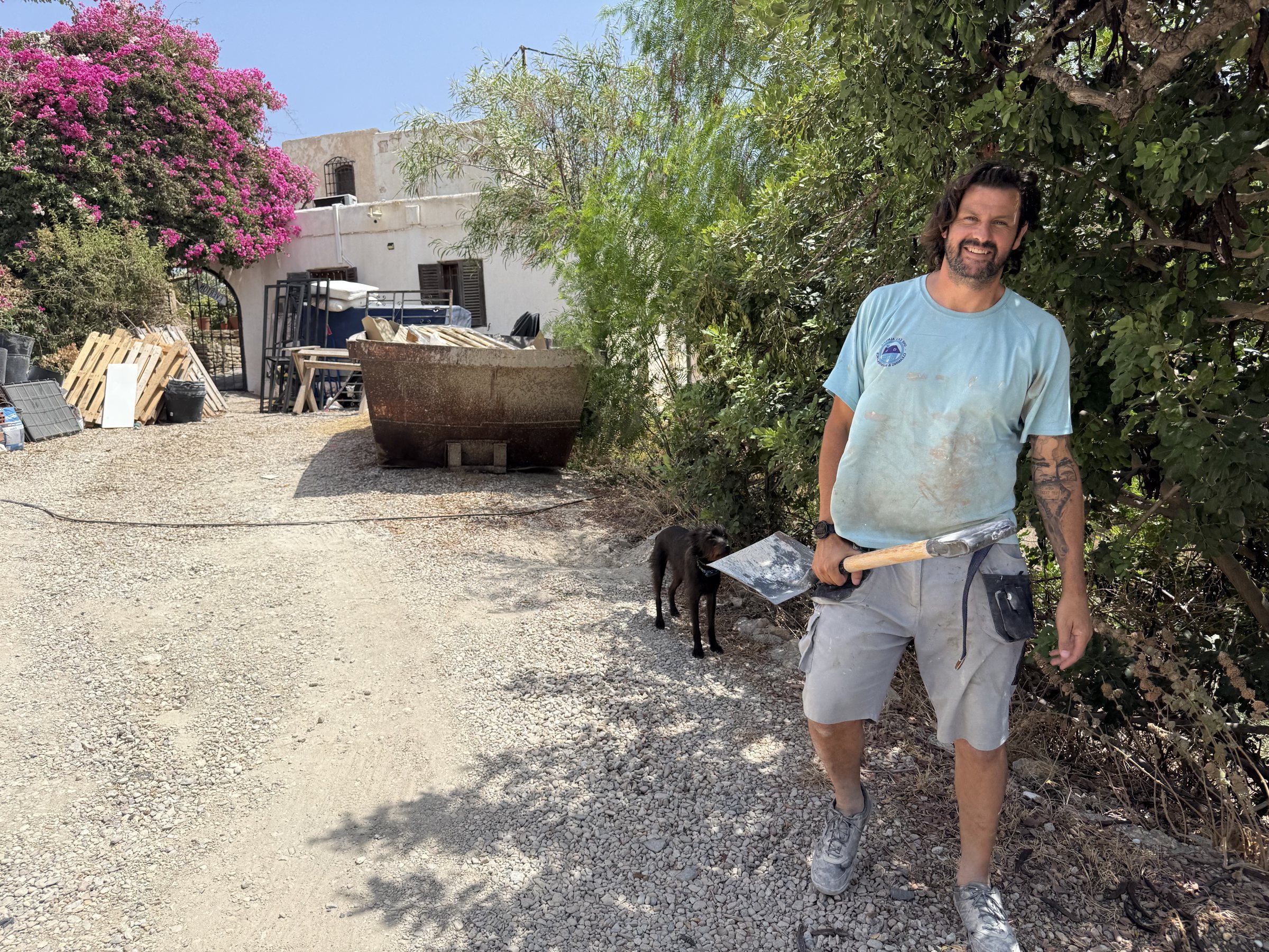 Leon Smith outdoors in work clothes, trowel in hand