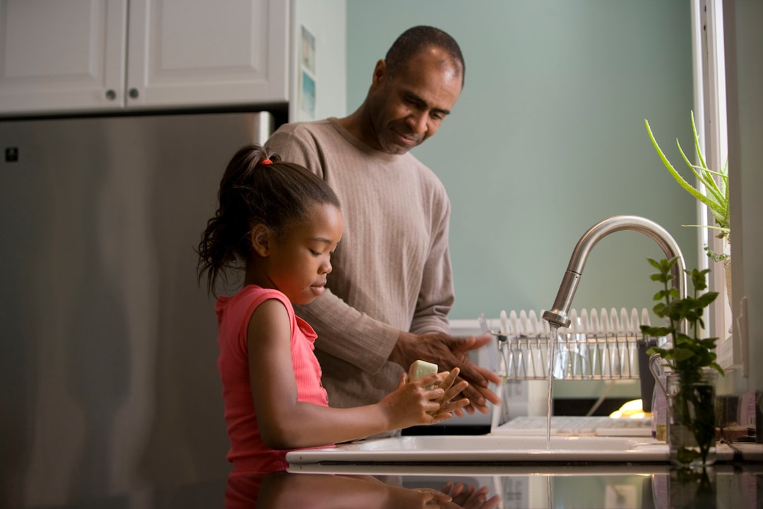dad washing dishes with daughter